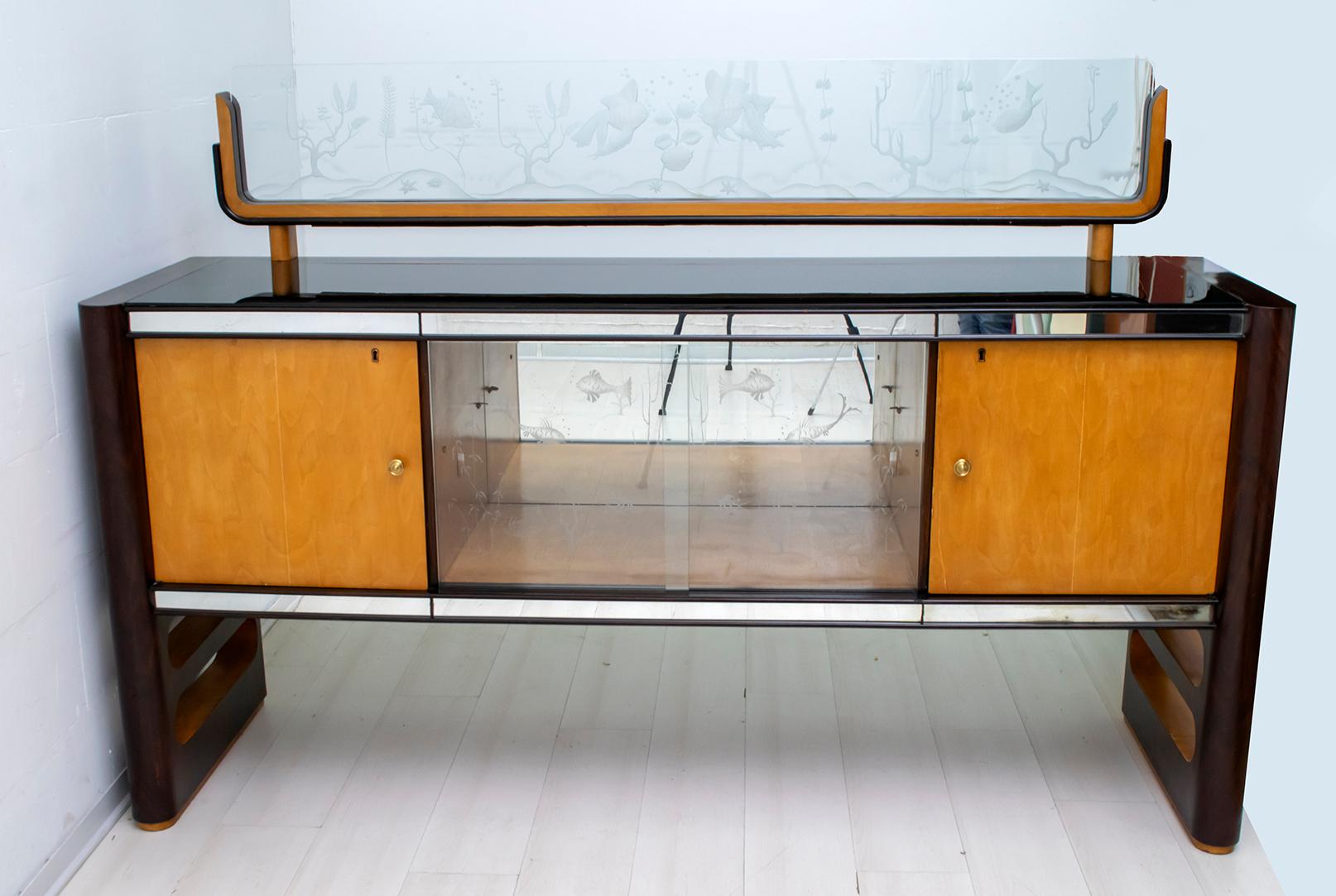 This bar sideboard was produced by Arredamenti Borsani Varedo, in Italy in the 1950s. The sideboard is in walnut and maple, mirrors and glass. The particularity is the overlying glass that reproduces a seabed, the glass has been engraved by hand, as