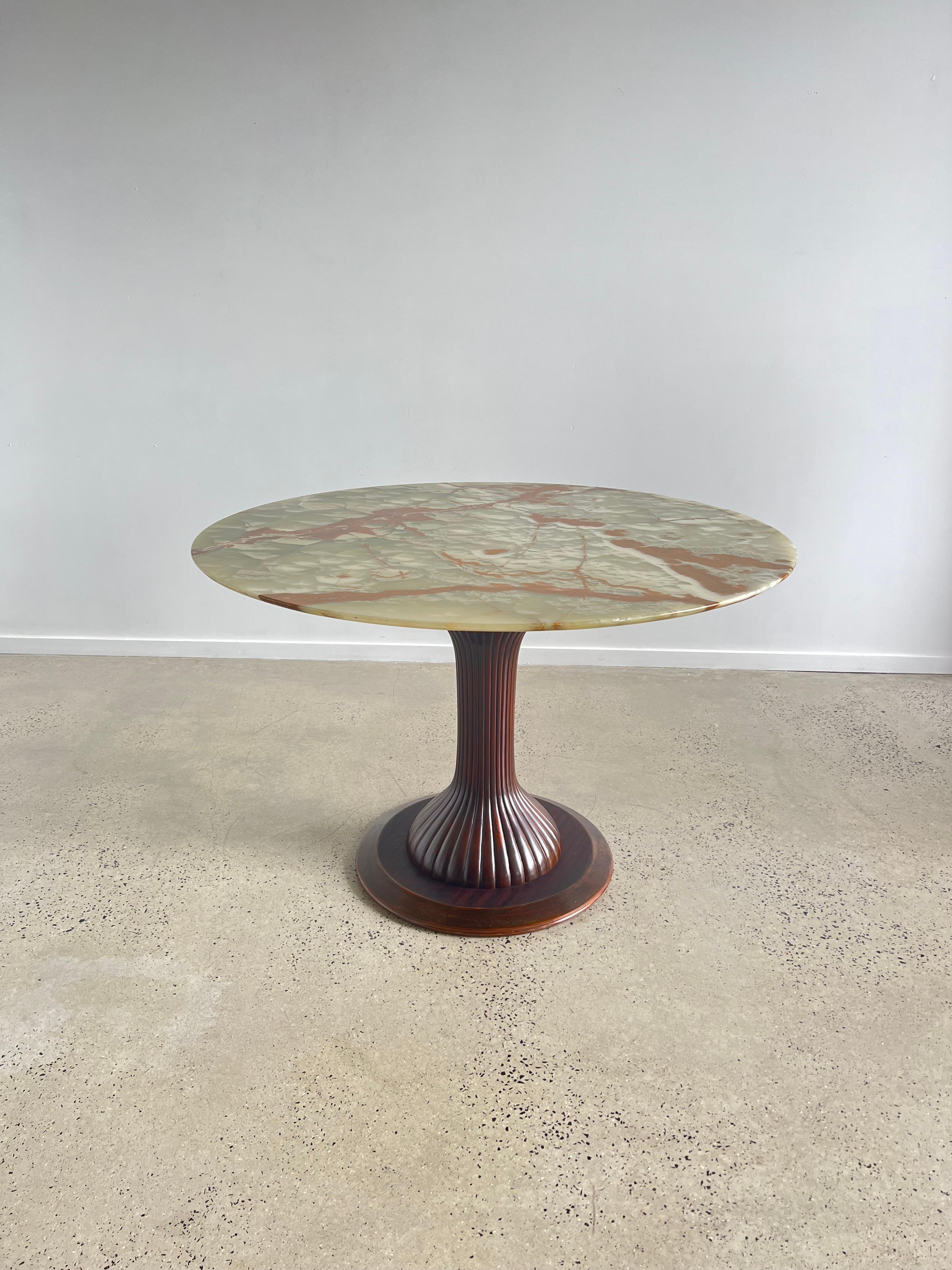 Osvaldo Borsani Italian 1950's Dining or Center Table. An Osvaldo Borsani tulip shaped dining table or center table. Designed for Arredamento Borsani, Italy, 1950s. The tulip shaped mahogany base is elegantly carved and fluted, with a marble