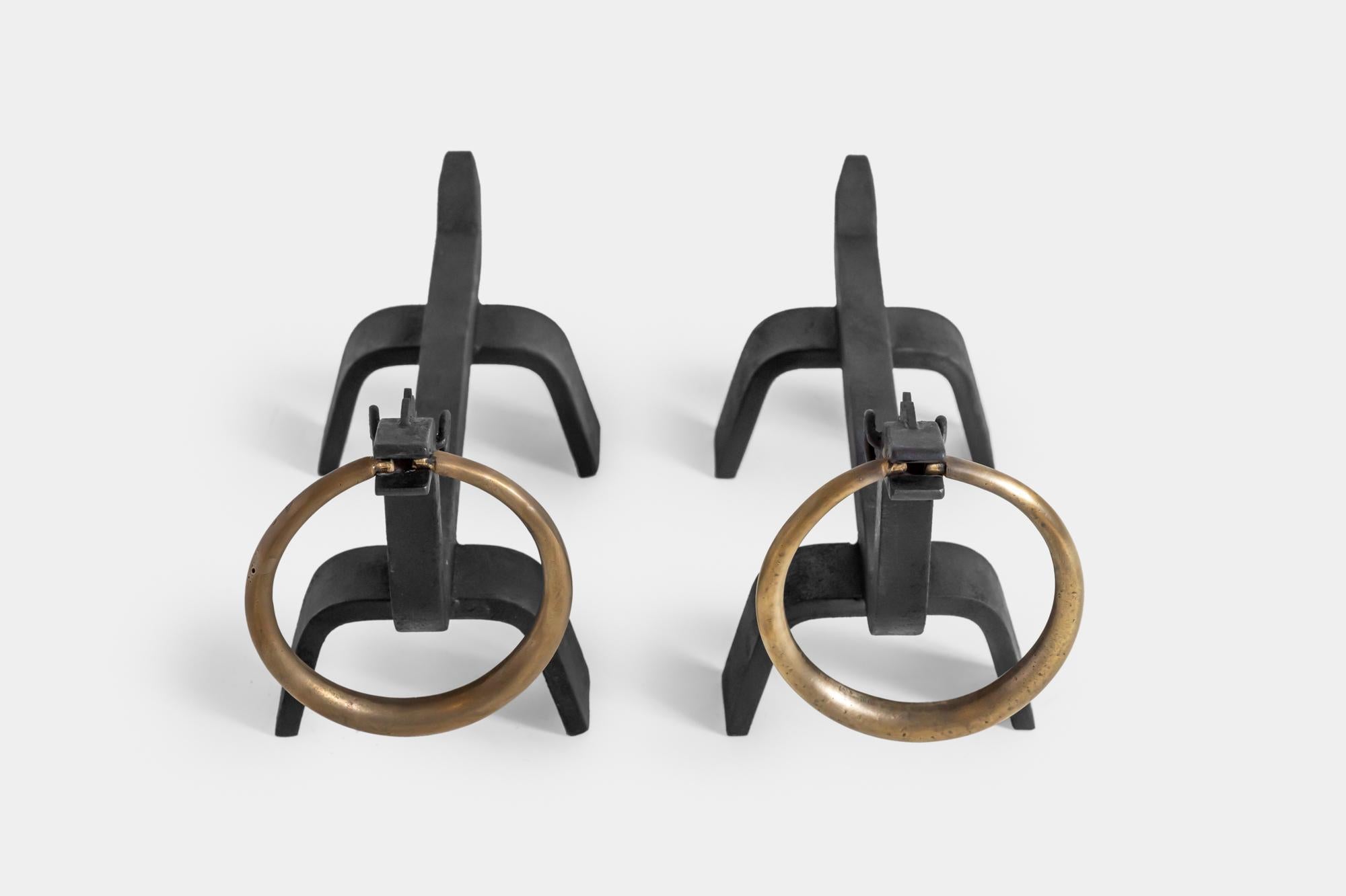 Designed by Osvaldo Borsani and manufactured by ABV Arredamenti Borsani-Varedo, pair of figural wrought iron andirons with brass details. 
Originally designed circa 1943 for the fireplace in the Villa Brianza designed by Lucio Fontana.