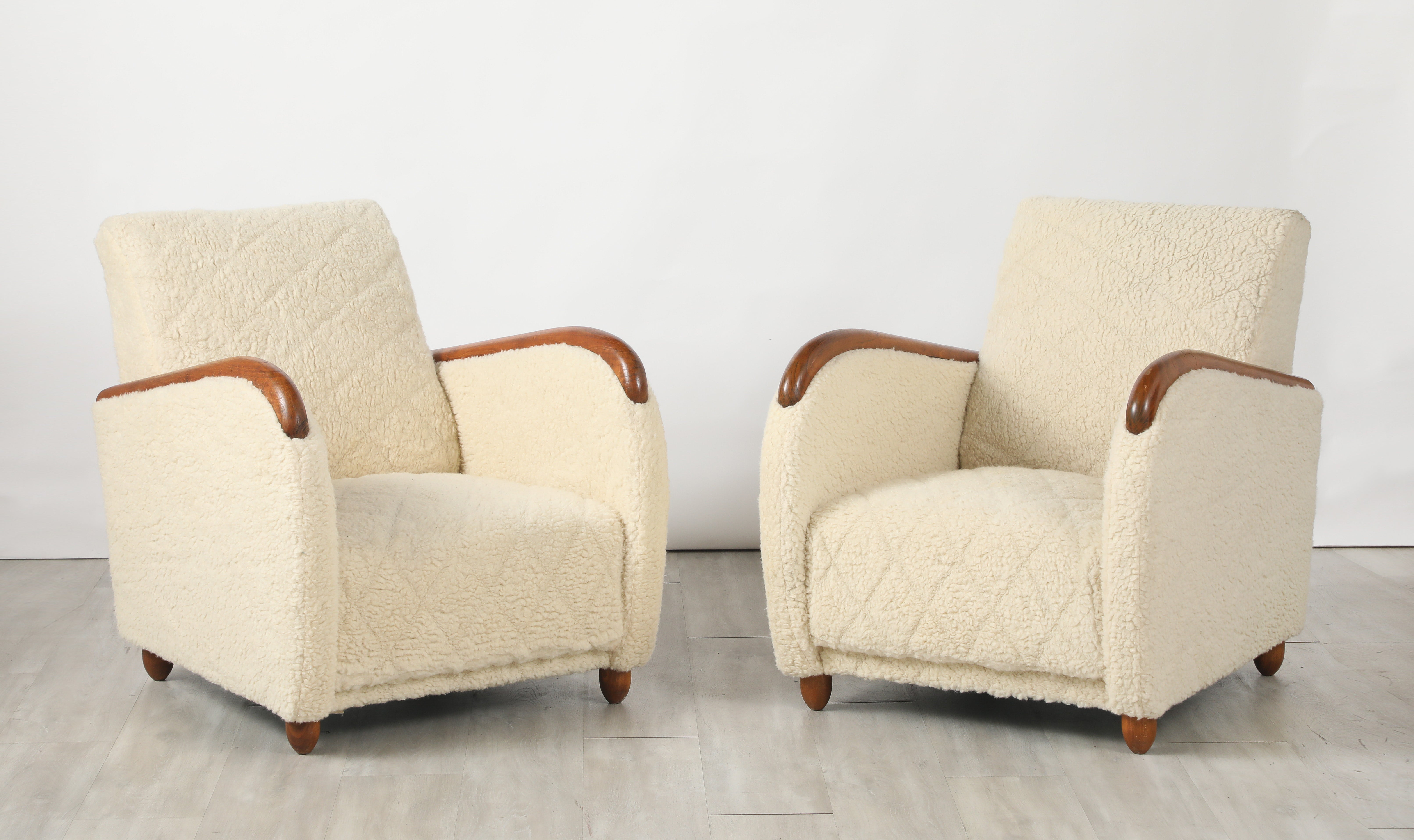 Un llamativo y elegante par de sillones de salón Art Decó diseñados por Osvaldo Borsani; su forma altamente escultural se ve realzada por los elegantes reposabrazos curvados de roble, que se extienden desde la parte delantera hasta la trasera, todo