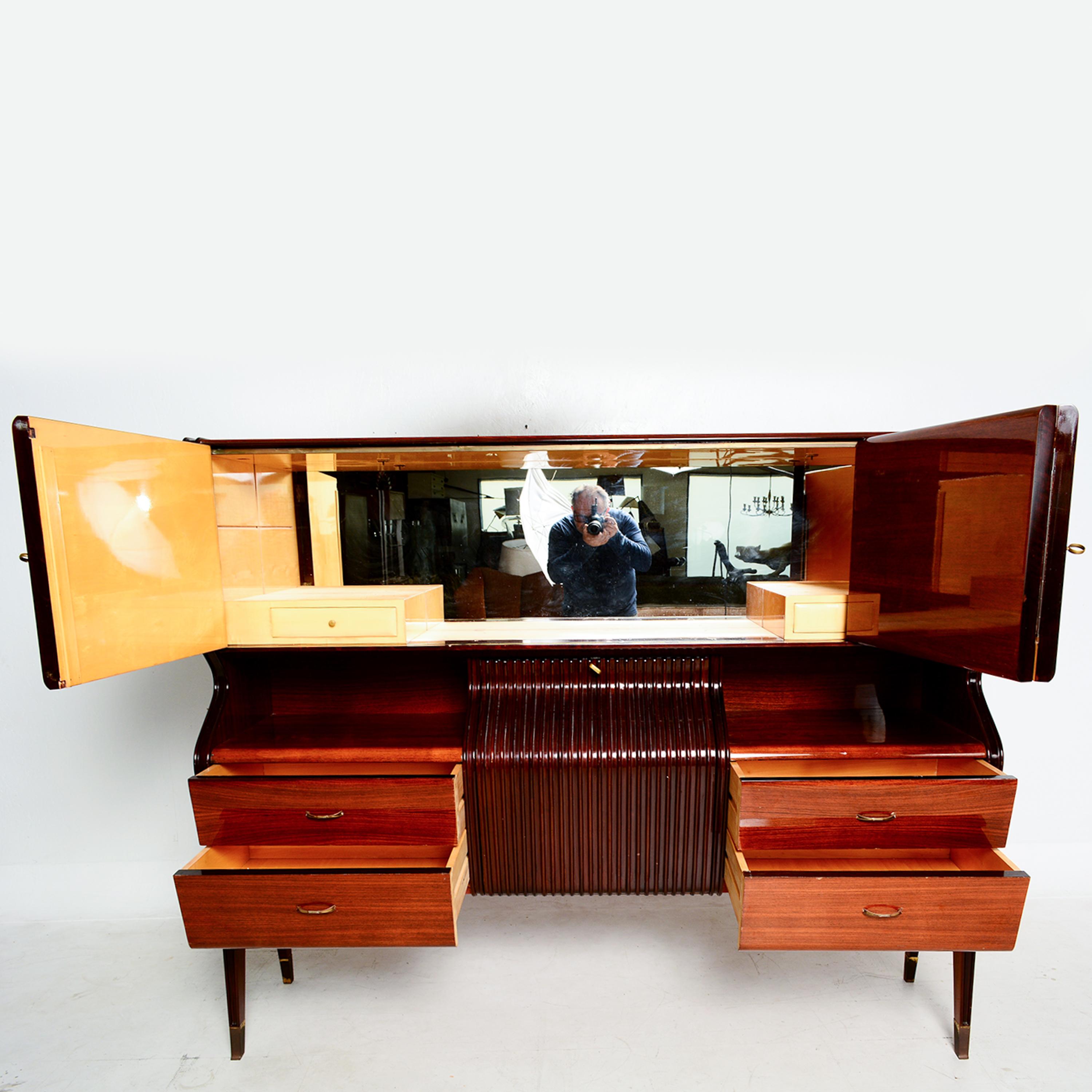 Sensational Bar Cabinet Credenza in Rosewood and Brass Italy Europe 1950s by Osvaldo Borsani.
No maker stamp.
Striking Presentation. Modern angular line.
Multifunctional piece; credenza, dry bar glass with interior mirror ample cabinet and drawer