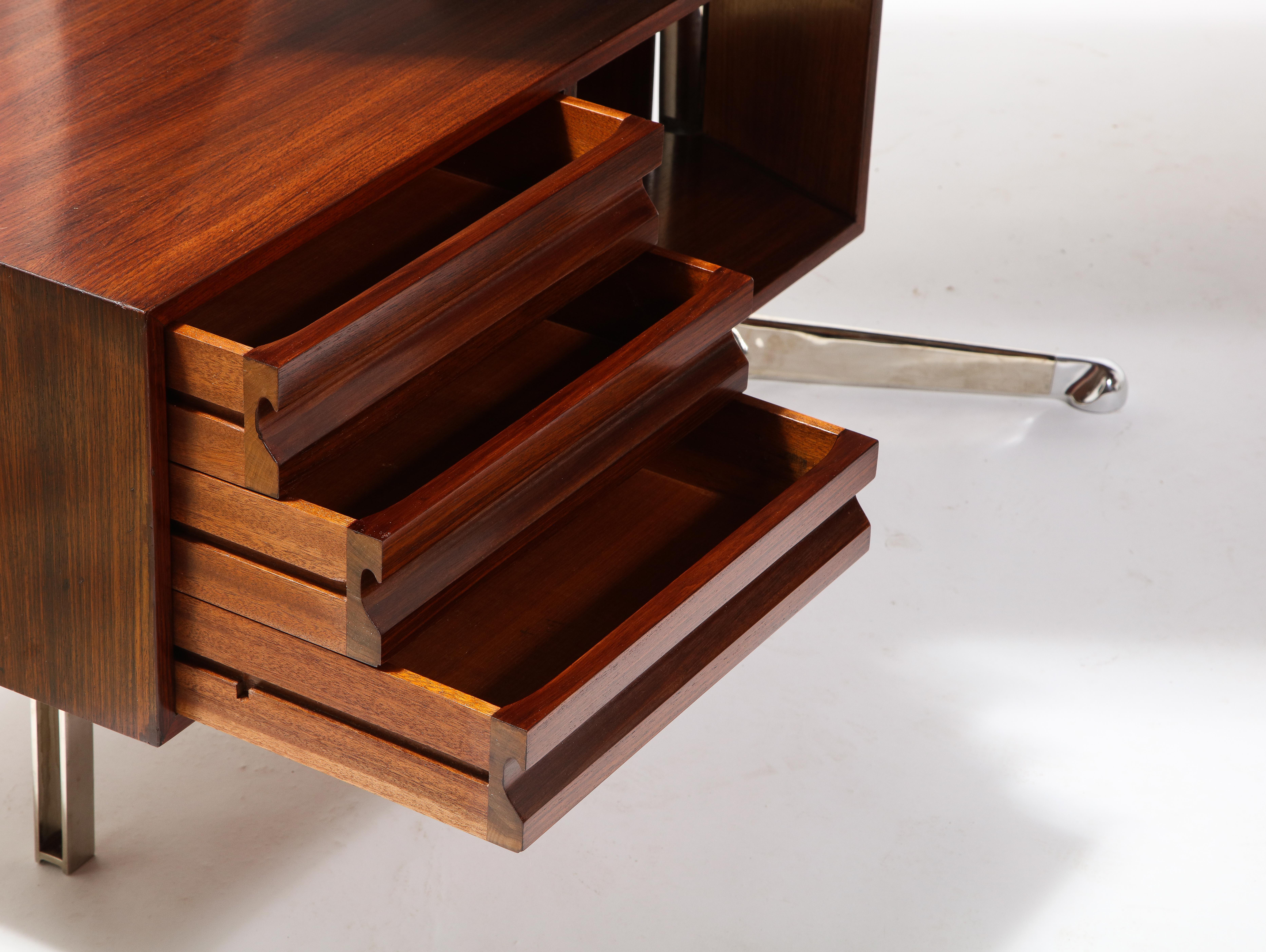 Large rosewood desk by Osvaldo Borsani for Tecno SPA, early edition with straight top and flat steel long drawer support. The drawer units rotate around the pedestal they're attached to. The desk is meant to float in a room.