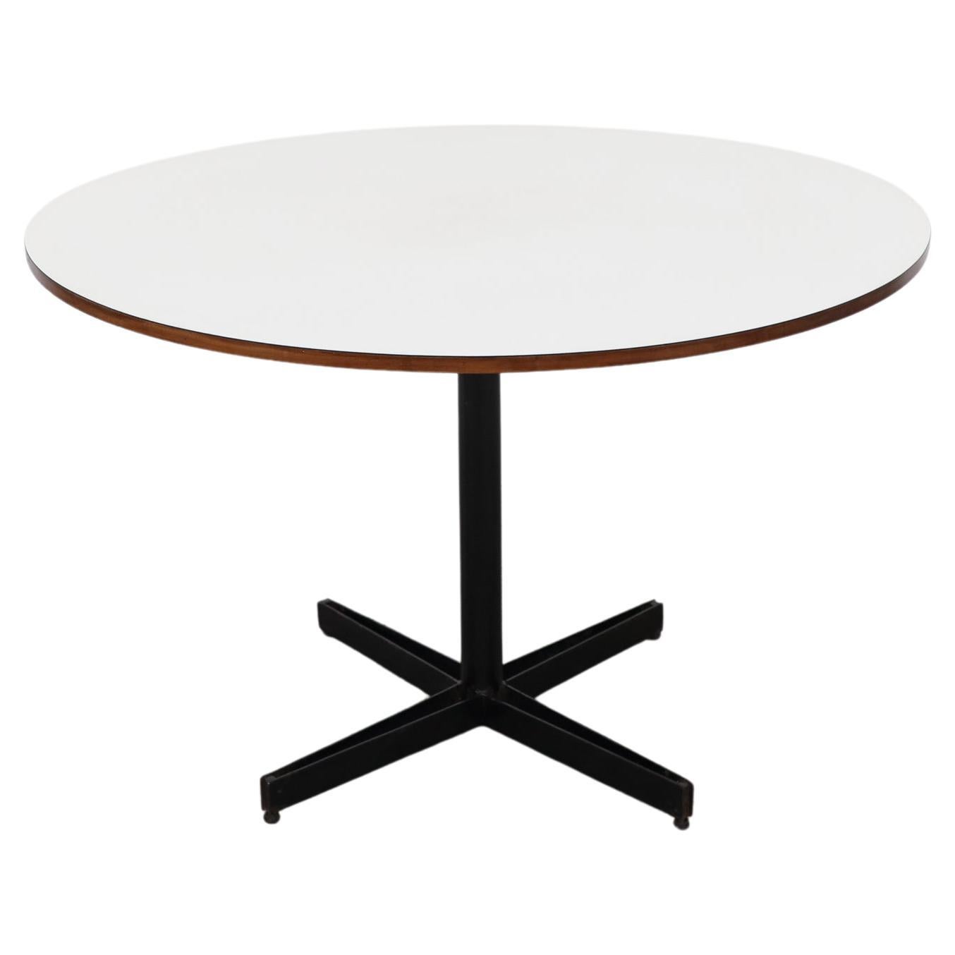 Osvaldo Borsani enameled metal pedestal table with white laminate top and teak edging. This simple flat metal fabrication highlights play with negative space. the metal is in original condition with signs of enamel loss and wear. The top shows