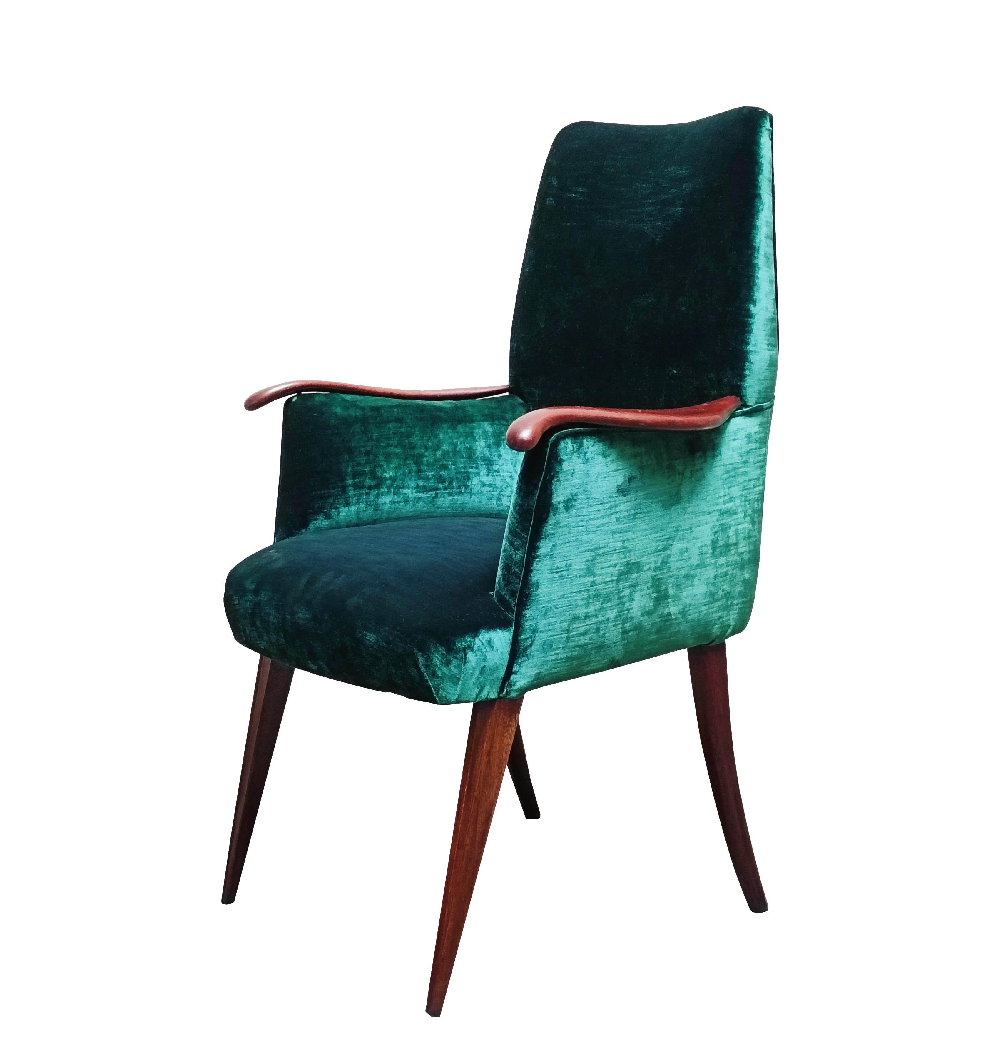 Un fauteuil rare et élégant des années 1960, dont la structure est en bois et le revêtement en velours vert émeraude. Les accoudoirs en bois courbés sont une caractéristique distinctive et offrent un soutien confortable. Parfait  pour un salon, un