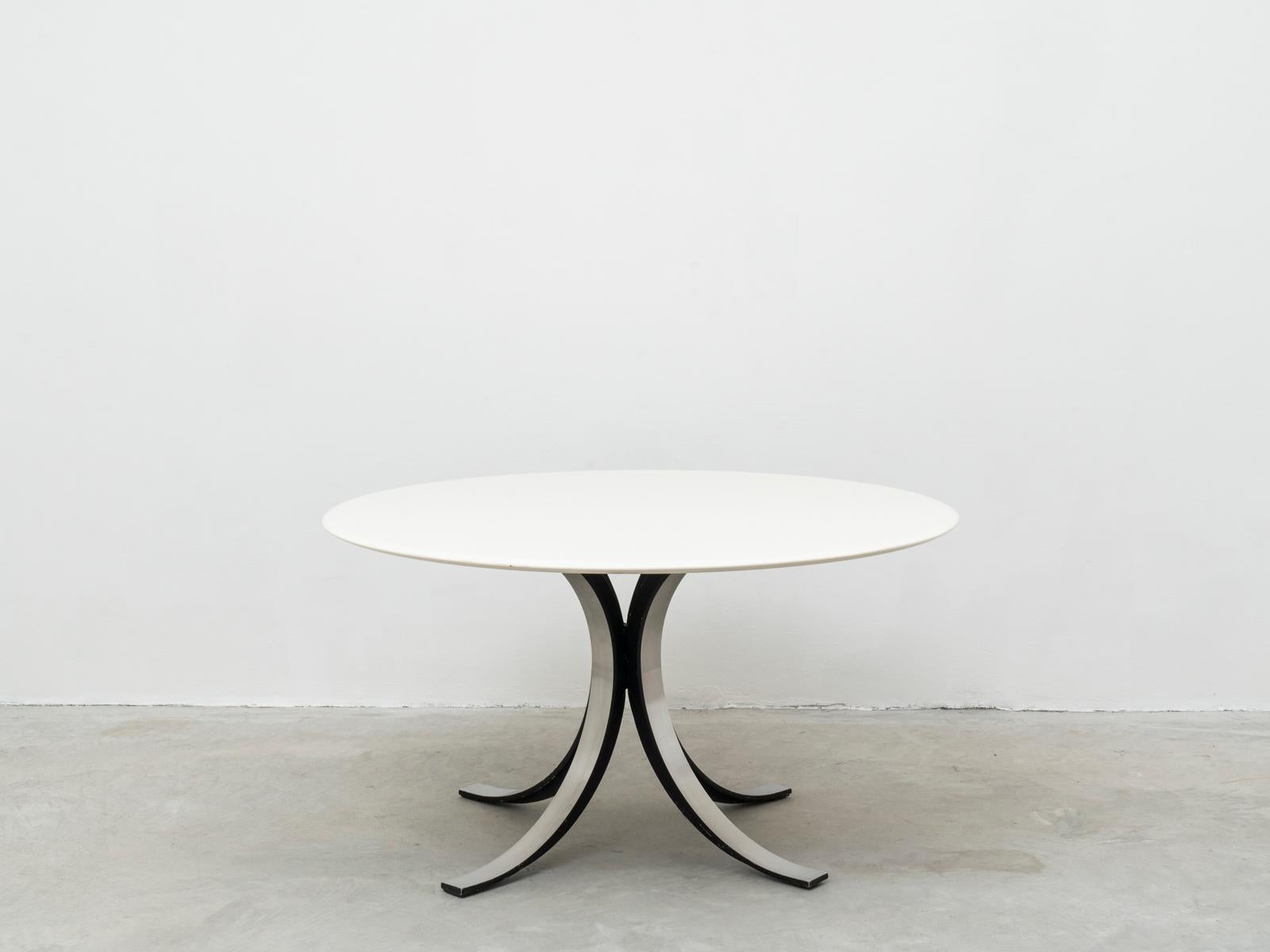 This iconic round table was designed by Italian design master Osvaldo Borsani together with his peer Eugenio Gerli in 1963 for Tecno, the manufacturer founded by Borsani himself. 
This table is made of a white lacquered wood top and a demountable