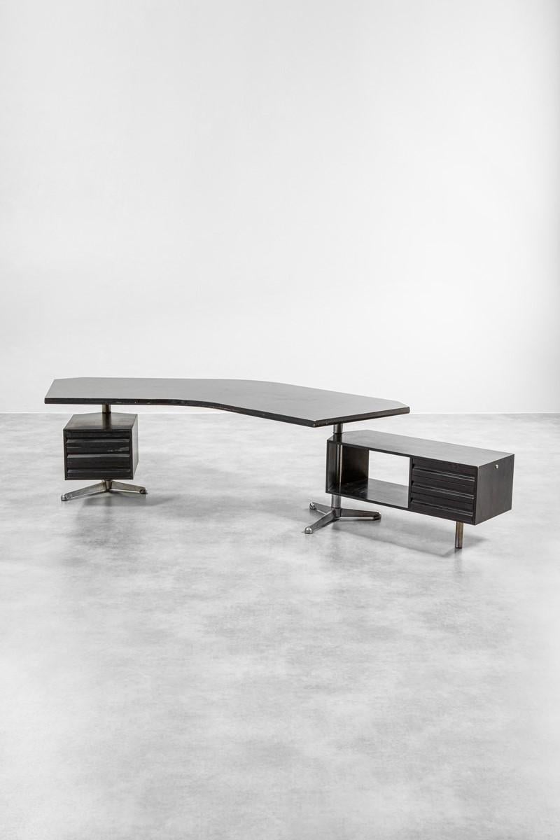 Desk T96 or boomerang in black lacquered wood, aluminium and metal. 
Designed by Osvaldo Borsani for Tecno, 1960.
With the manufacturer’s mark inside a drawer.

Dimensions: cm 73 x 250 x 105, big chest of drawers cm 106 x 42, small chest of
