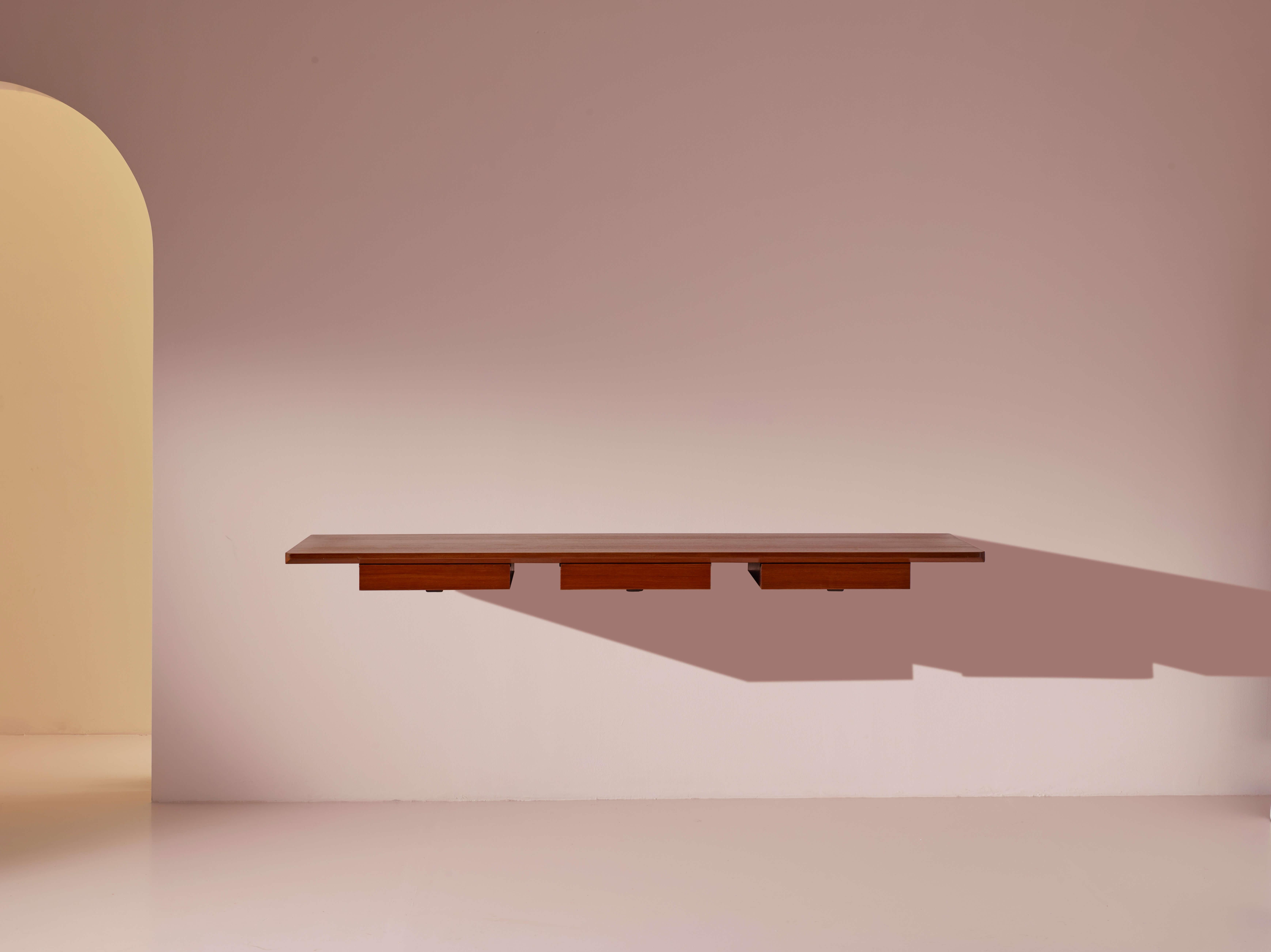 Bureau mural en bois, métal et laiton, de la série E22, produit par Tecno, conçu par Osvaldo Borsani, années 1950.

Un meuble mural, sans support au sol, attire toujours l'attention par son esthétique légère et fonctionnelle. Ce vaste bureau à