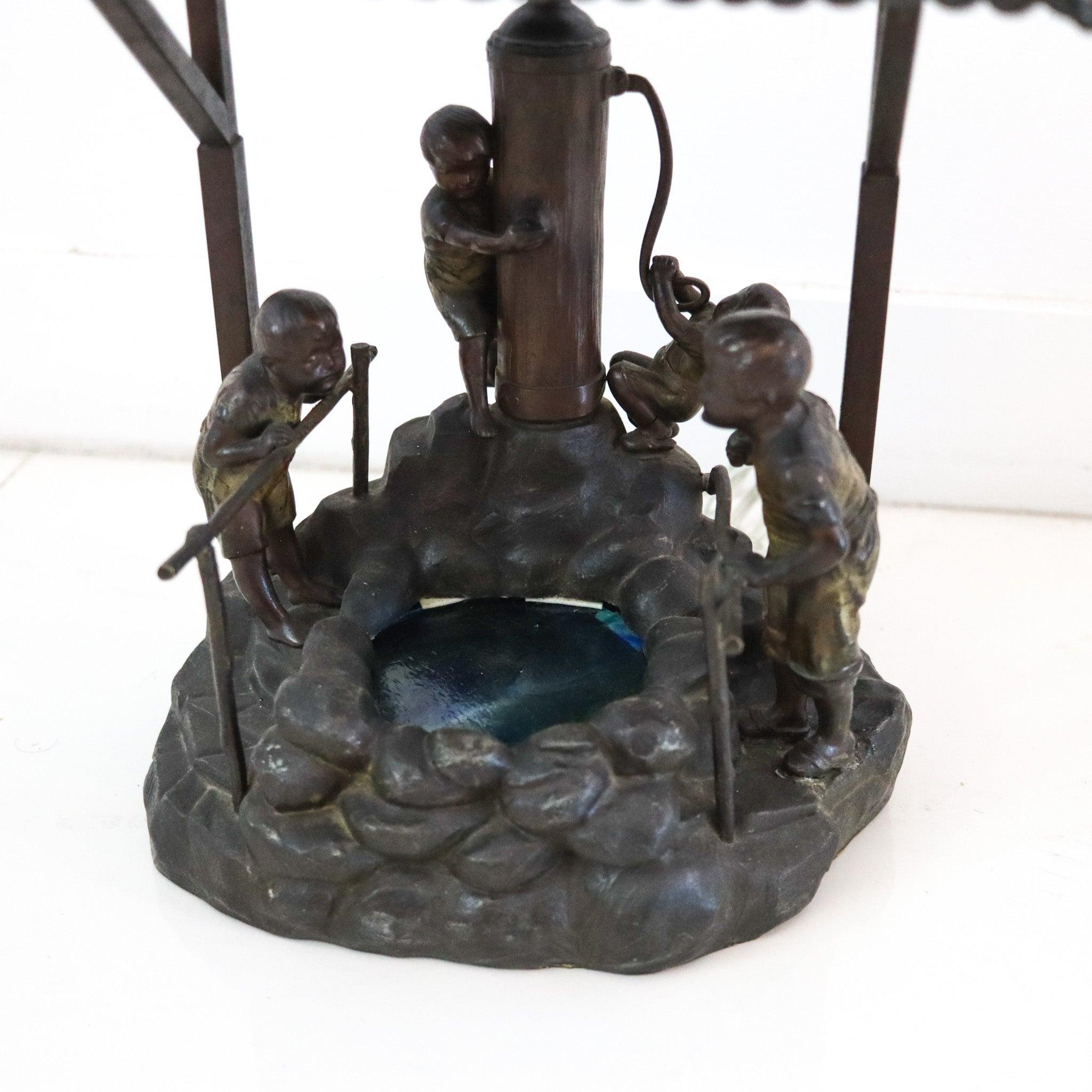 Lampe de bureau conçue par Oswald Schimmelpfennig.

Il s'agit d'une lampe de table fantaisiste inhabituelle, créée à Berlin en Allemagne par Oswald Schimmelpfennig, dans les années 1900. La lampe antique a été magistralement transformée en diorama