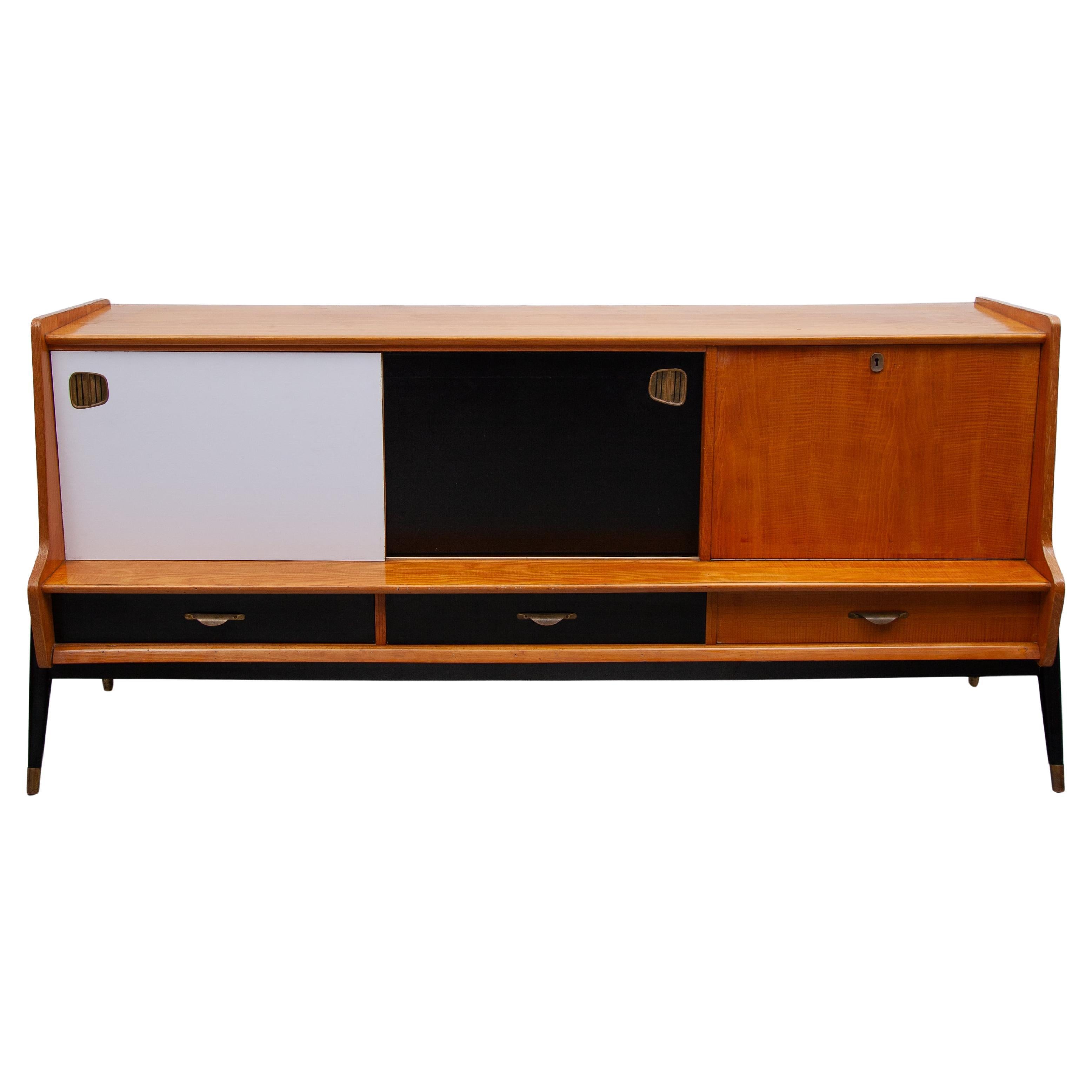 Un'edizione speciale del designer Oswald Vermaercke, associato alla V-Form Manufacture di Gand, che negli anni '50 progettò mobili moderni contemporanei per la nuova casa. Questa versione con ante scorrevoli progettate in laminato bianco e nero dà