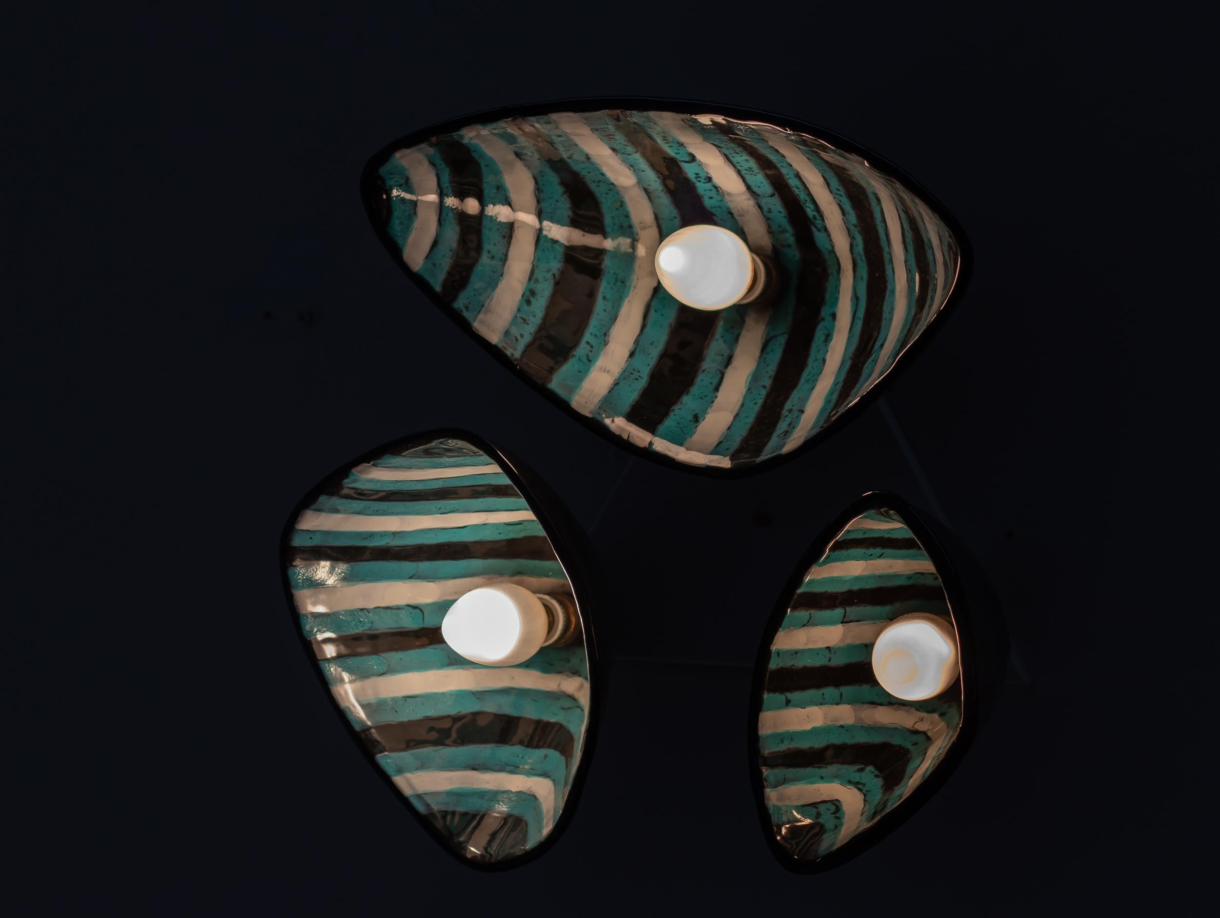 Excepcional aplique o lámpara de techo de mayólica italiana creado por Otello Rosa en el estudio de cerámica italiano de San Polo, hacia 1950. Esta hermosa pieza consta de tres conchas de cerámica giratorias hechas a mano y montadas sobre una placa