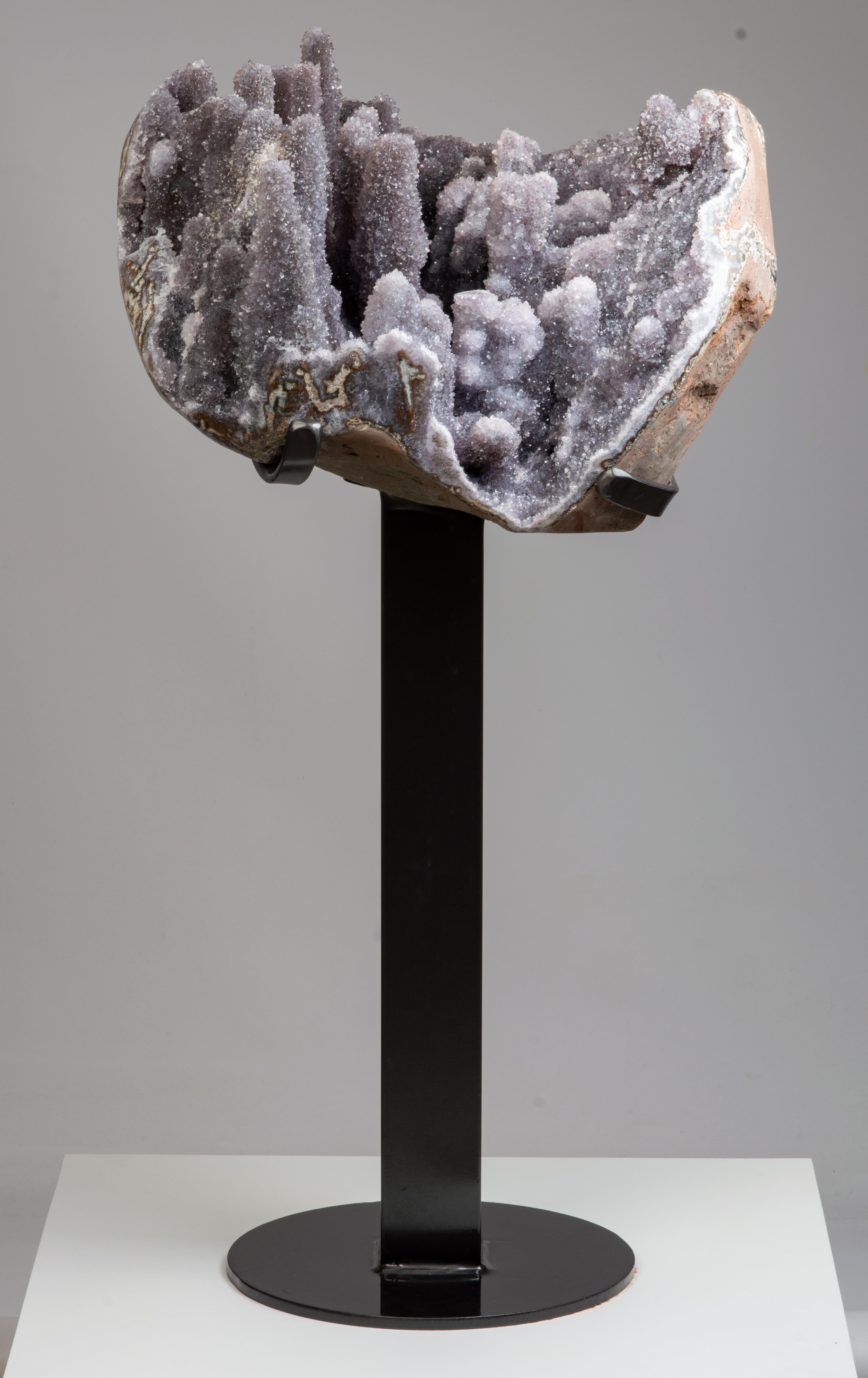 A stunning half geode containing many tall stalactites resembling an other
worldly landscape. The stalactites covered in grey-lilac druzy quartz. the borders
polished.

This piece was legally and ethically sourced directly in the prestigious