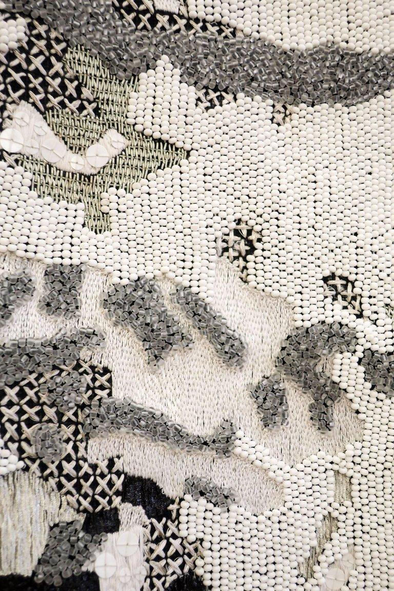 Une pièce d'art magnifique et imponante. Une tenture murale noire et blanche brodée de perles, de bulles et de différents points de couture. Cela ne passera pas inaperçu.
L'artiste, Geraldine Larkin, a combiné différentes techniques et matériaux