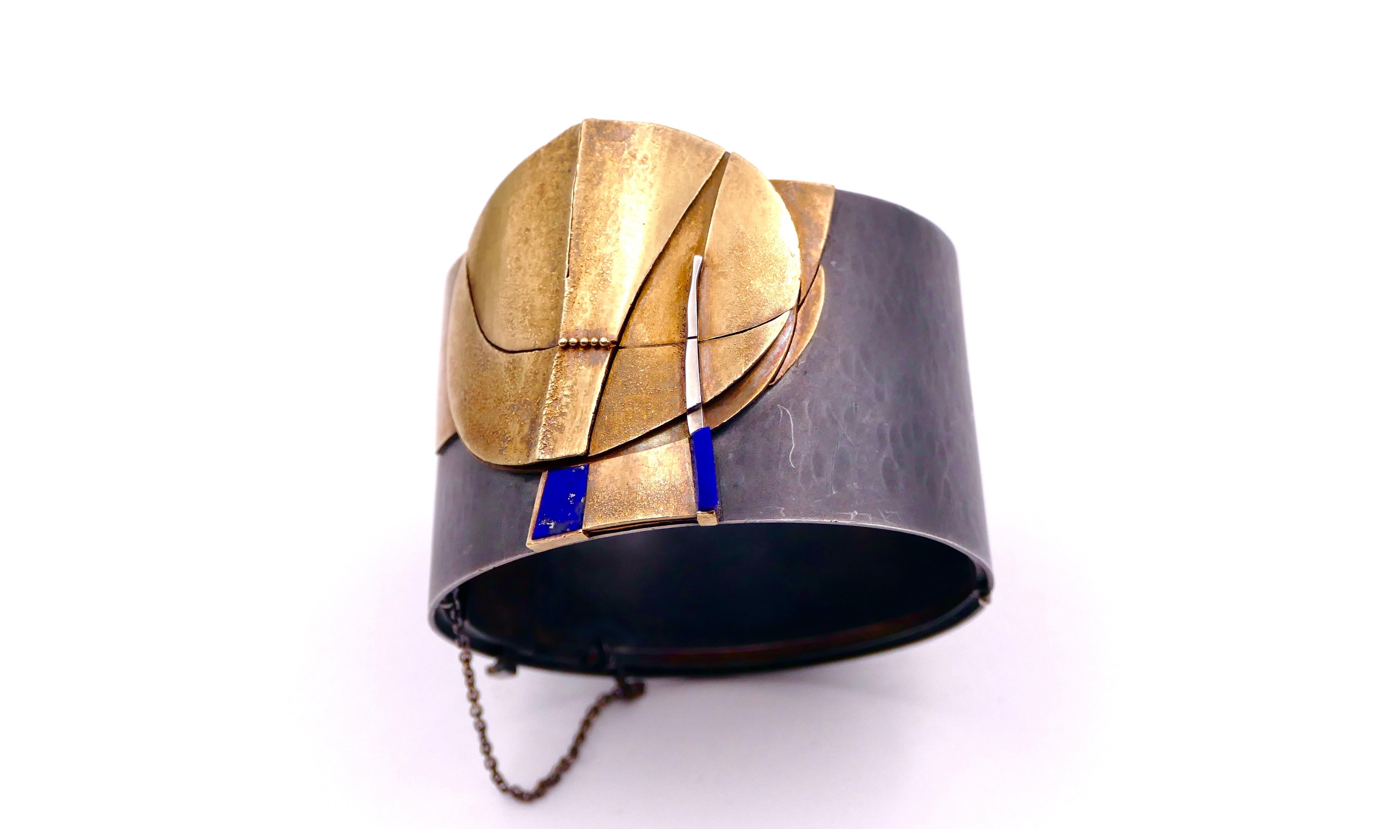 A stunning and rare cuff bracelet showcasing an extraordinary abstract design, masterfully crafted in silver, gold, and vibrant lapis lazuli by the renowned Swiss goldsmith Othmar Zschaler (1930–2023). 
(FITS A SMALL TO MEDIUM WRISTS -  inner