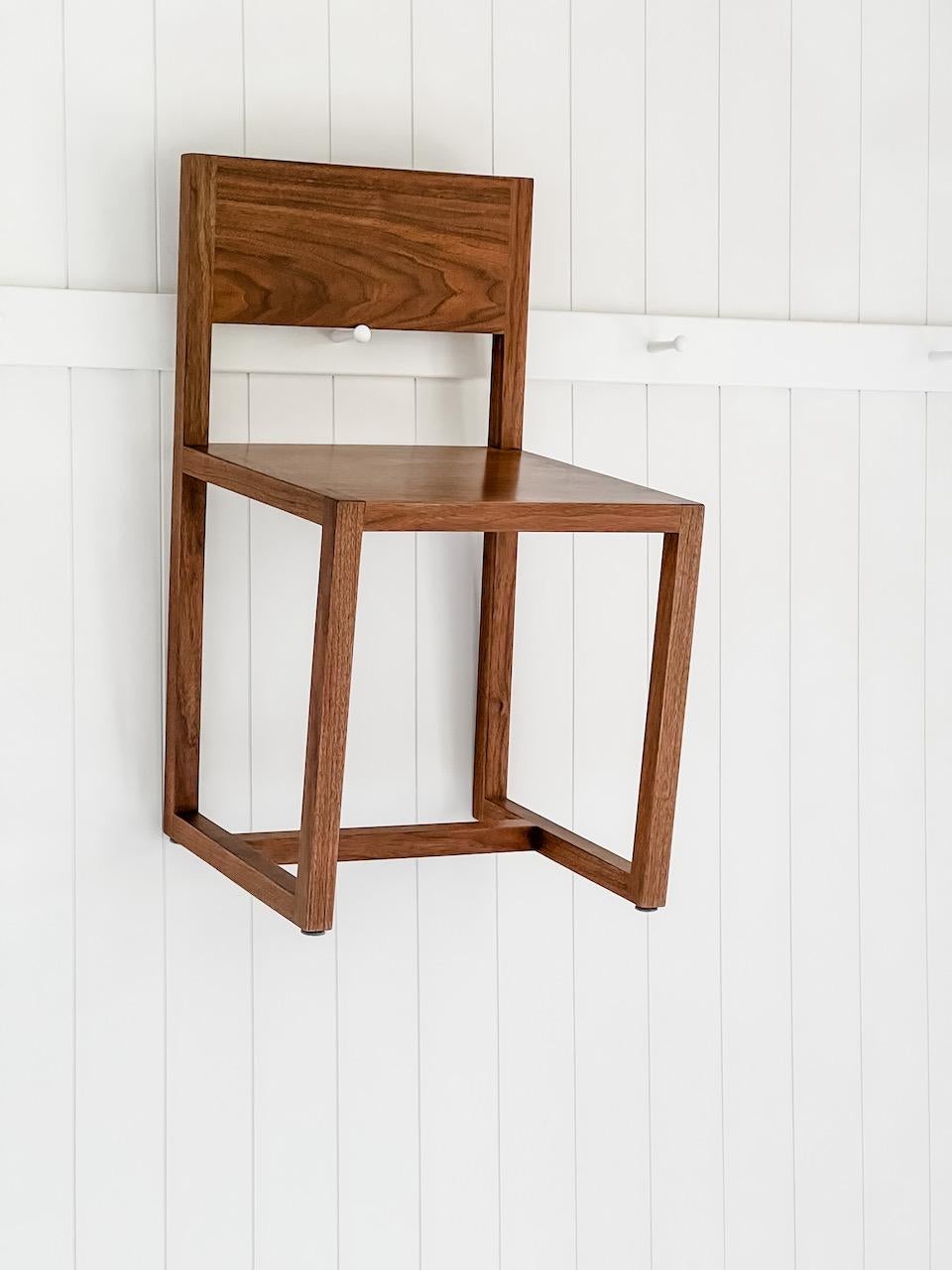 Simple dining chair with slightly angled back leg and back rest.
