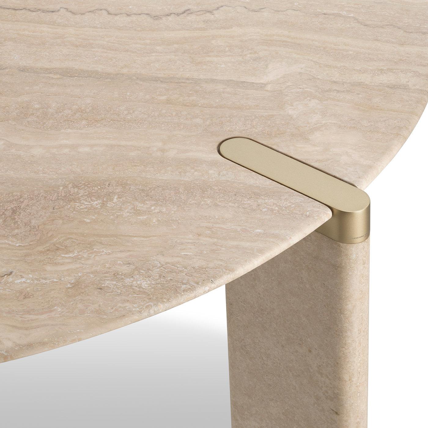 A design coupling luxury and sleekness, this round dining table was designed by Lorenza Bozzoli to allow the travertine marble's bare beauty fiercely shine through. Satin brass details accent the silhouette, where the circular top (Ø 160cm) is