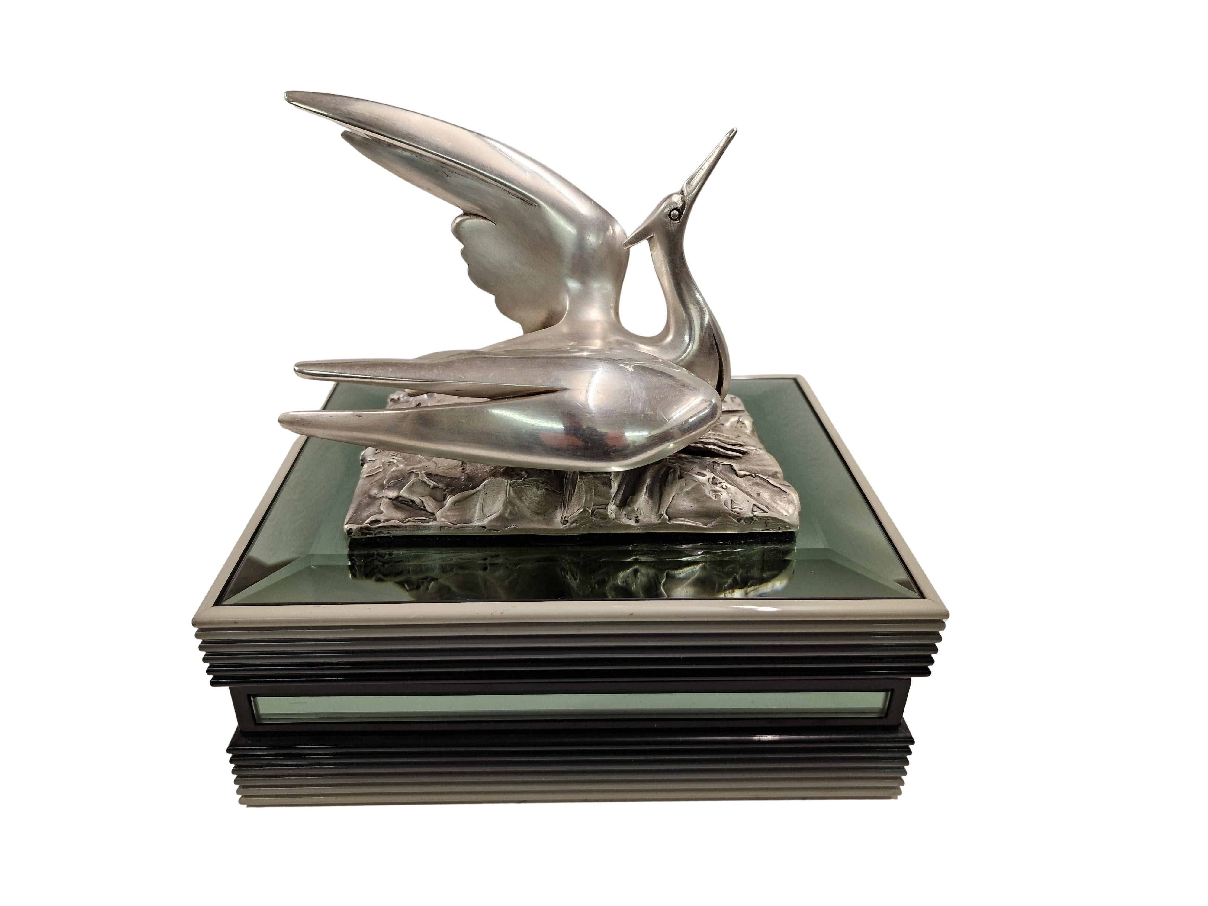 Maravillosa caja italiana de mediados de siglo con tapa de plata de ley, con figura de grulla y parcialmente espejada. 

La tapa de plata de ley 925 está magistralmente decorada con una base abstracta, de forma rectangular, que representa