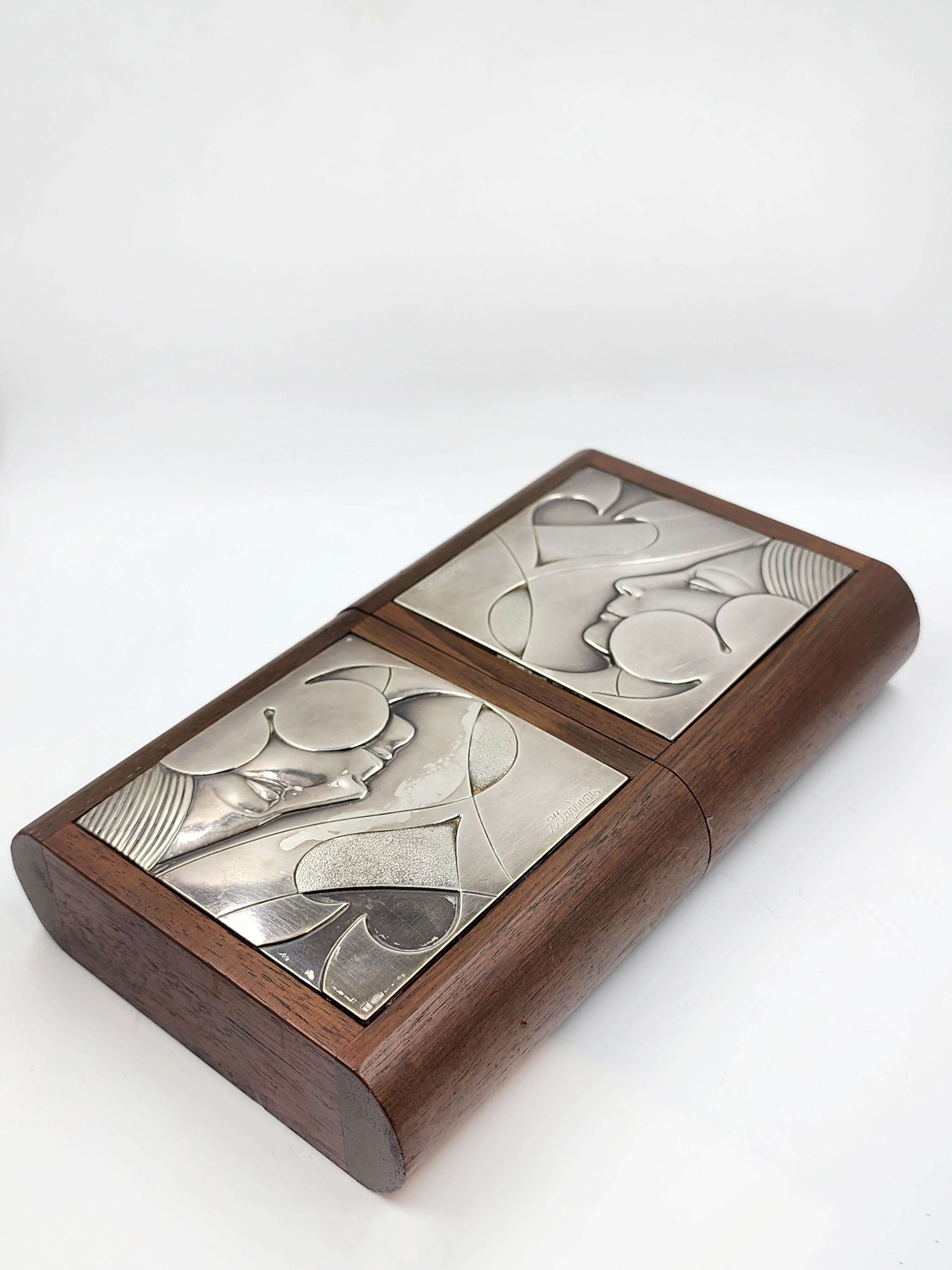 Ottaviani Italienische Spielkartenbox
Diese Ottaviani Italian Playing Card Box wird als elegante Doppelkassette aus poliertem Walnussholz präsentiert. Sein Design zeichnet sich durch geprägte Silberplatten aus, die die Oberseite jedes Fachs zieren