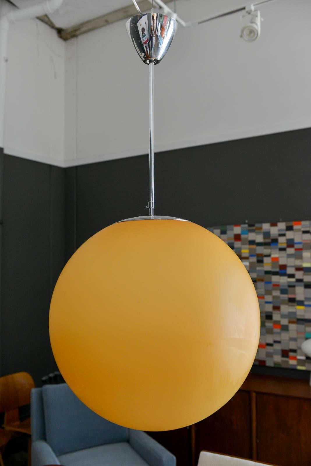 'Otto' amber glass globe pendant by Ben Swildens for Fontana Arte, 1994. Beautiful diffused light from this blown glass amber pendant light suspended with original chrome down-rod and new wiring. Uses a 100W incandescent bulb, can also use an LED.