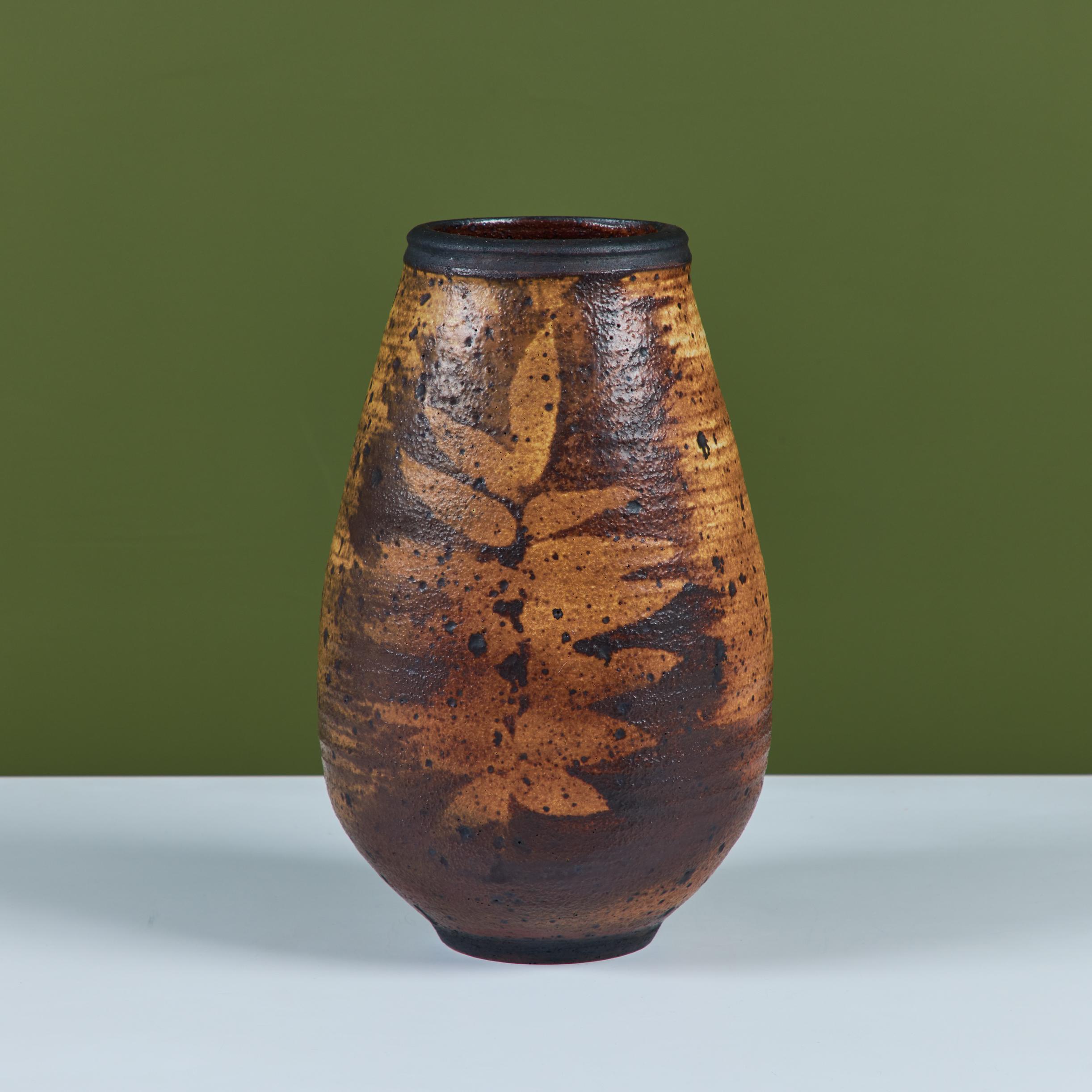Vaso in Studio Pottery di Otto and Vivika Heino, coppia di ceramisti moderni della California, 1984 circa, USA. Il pezzo, realizzato a ruota, presenta uno smalto marrone all over e un motivo di foglie impresso a mano.  Firma impressa sul lato