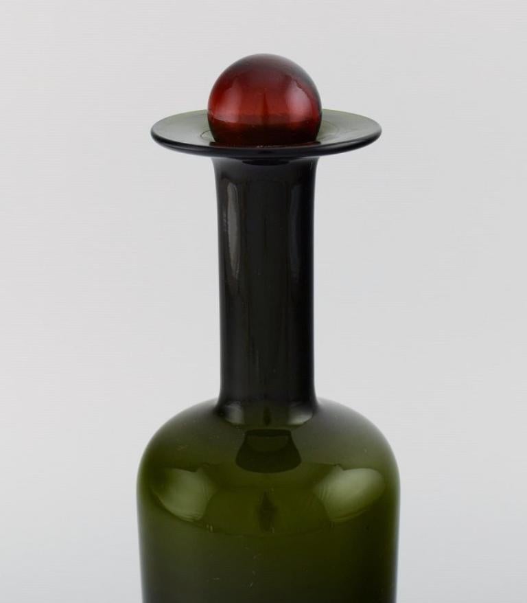 Otto Brauer for Holmegaard. 
Large vase / bottle in green art glass with red ball. 1960's.
Measures: 28 x 9.5 cm (incl. Ball).
In perfect condition.