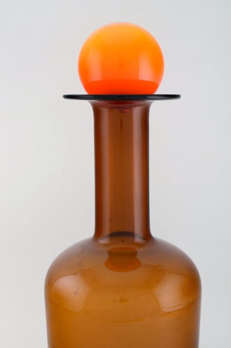 Otto Brauer für Holmegaard. 
Große Vase/Flasche aus hellbraunem Kunstglas mit orangefarbener Kugel. 1960's.
Maße: 51 x 17 cm (inkl. Ball).
In perfektem Zustand.
    