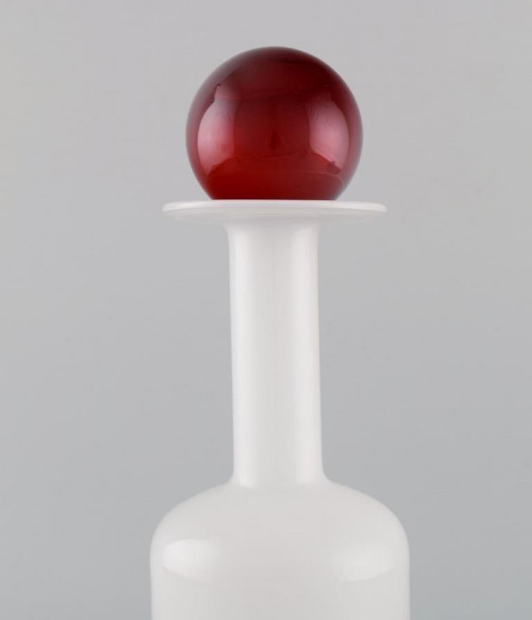 Otto Brauer for Holmegaard. 
Vase / bottle in white art glass with red ball. 1960s.
Measures: 36.5 x 12 cm (incl. Ball).
In perfect condition.