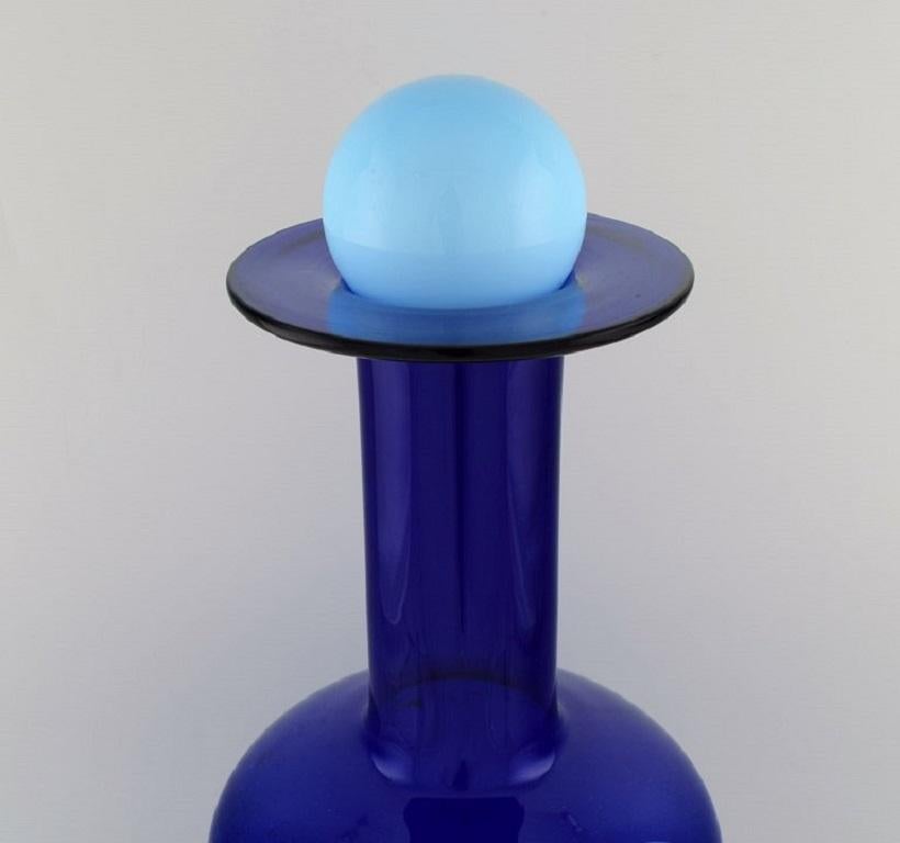 Otto Brauer for Holmegaard. 
Large vase / bottle in blue art glass with light blue ball. 1960's.
Measures: 56 x 21 cm (incl. Ball).
In perfect condition.