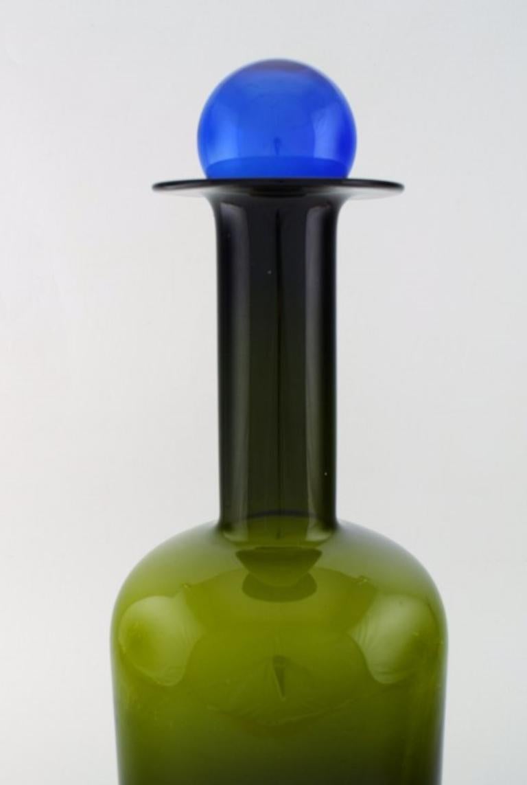 Otto Brauer für Holmegaard. 
Große Vase / Flasche aus grünem Kunstglas mit blauer Kugel, 1960er Jahre.
Maße: 51 x 17 cm (inkl. Ball).
In perfektem Zustand.
   