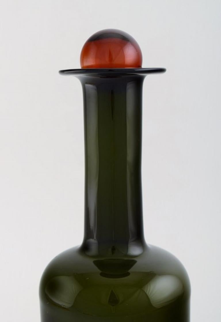 Otto Brauer für Holmegaard. 
Große Vase / Flasche aus grünem Kunstglas mit roter Kugel. 1960's.
Maße: 29 x 9,5 cm (inkl. Kugel).
In perfektem Zustand.