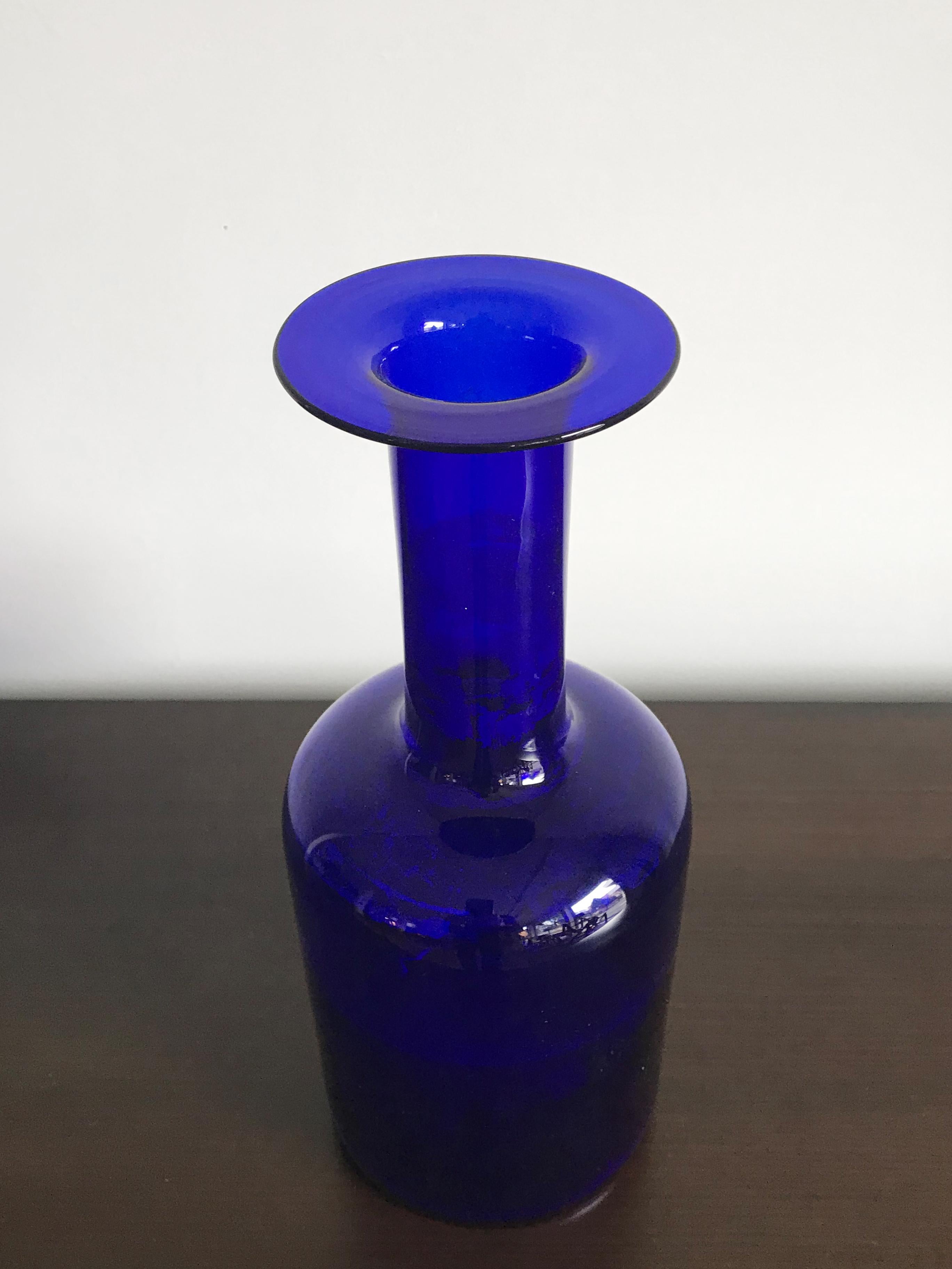 Iconic blue glass Scandinavian bottle or vase designed by Otto Brauer for Holmegaard, made in Denmark 1960s.

Please note that the vase is original of the period and this shows normal signs of age and use.
 