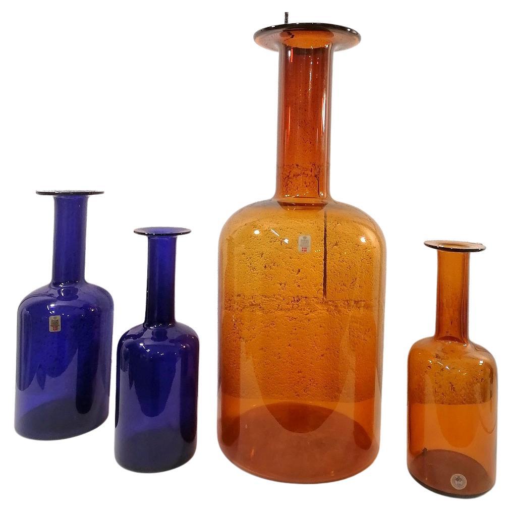 Otto Brauer Set of 4 Scandinavian vase bottle Holmegaard 1960

Set of 4 Otto Bauer Vases
2 brown / amber and 2 blue
One big vase or bottle in brown art glass
Height 50cm, diameter 20cm
Other dimensions : Height, 26cm, 26cm, 31cm

Very good