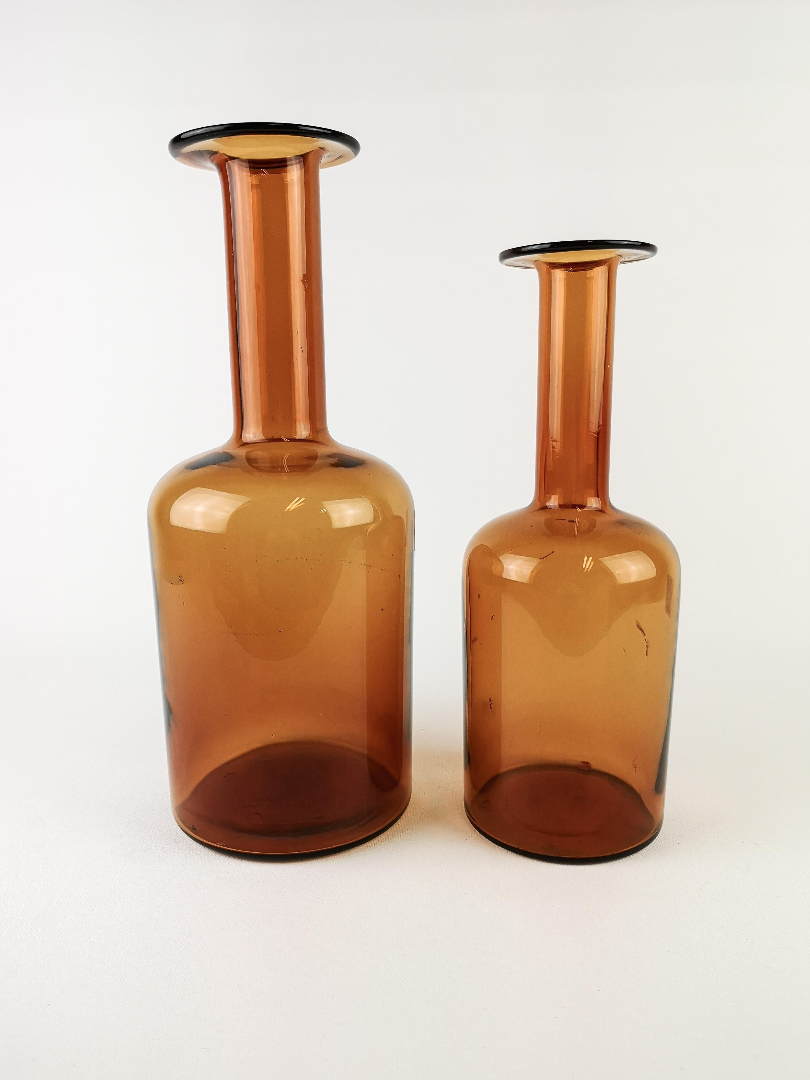 Set of two amber color glass vases designed by Otto Breuer for Kastrup Holmegaard in Denmark during the 1950s. 

Some dirt in the smaller one. 

The big one H 30 cm, W 12 cm Small one H  26cm W 10 cm.