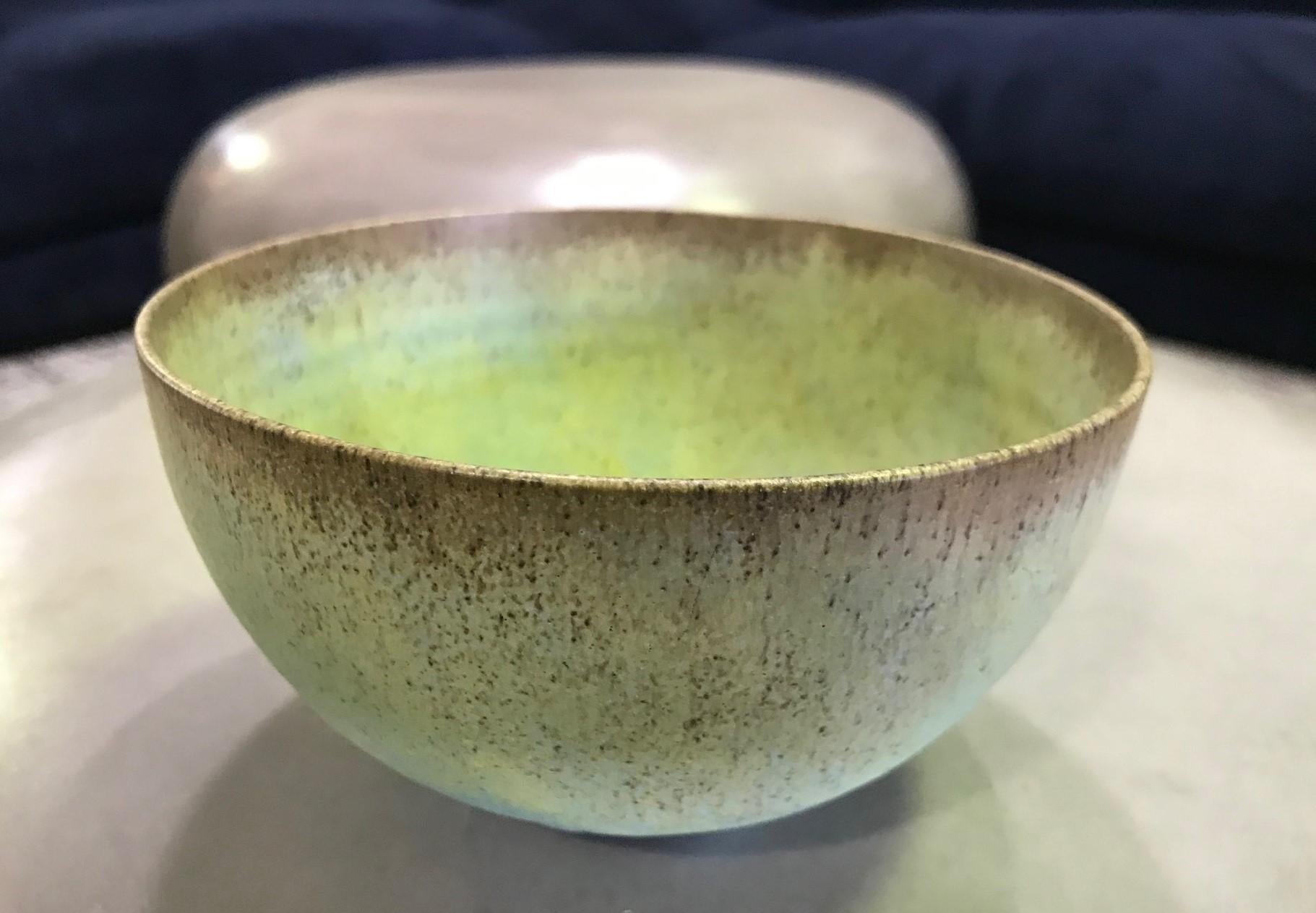 A masterful work by famed potters Otto and Gertrud Natzler. This round-shaped bowl was delicately hand thrown and formed by Gertrud and glazed by Otto with one of his famed early volcanic crater glazes which exhibits a vast array of colors ranging