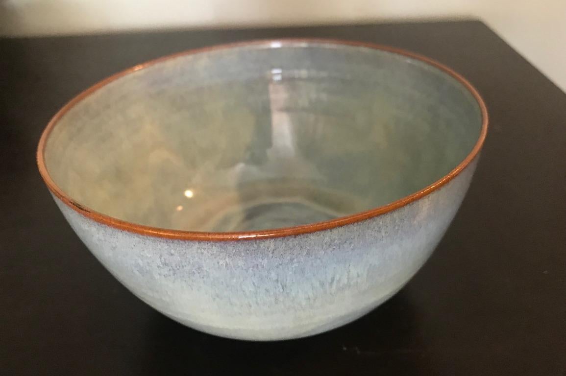 Another sublime work by famed pottery masters Otto and Gertrud Natzler. This round-shaped, eggshell thin-walled bowl was hand thrown and formed by Gertrud and glazed by Otto with a beautiful pearl green/blue glaze. The bowl radiates in the