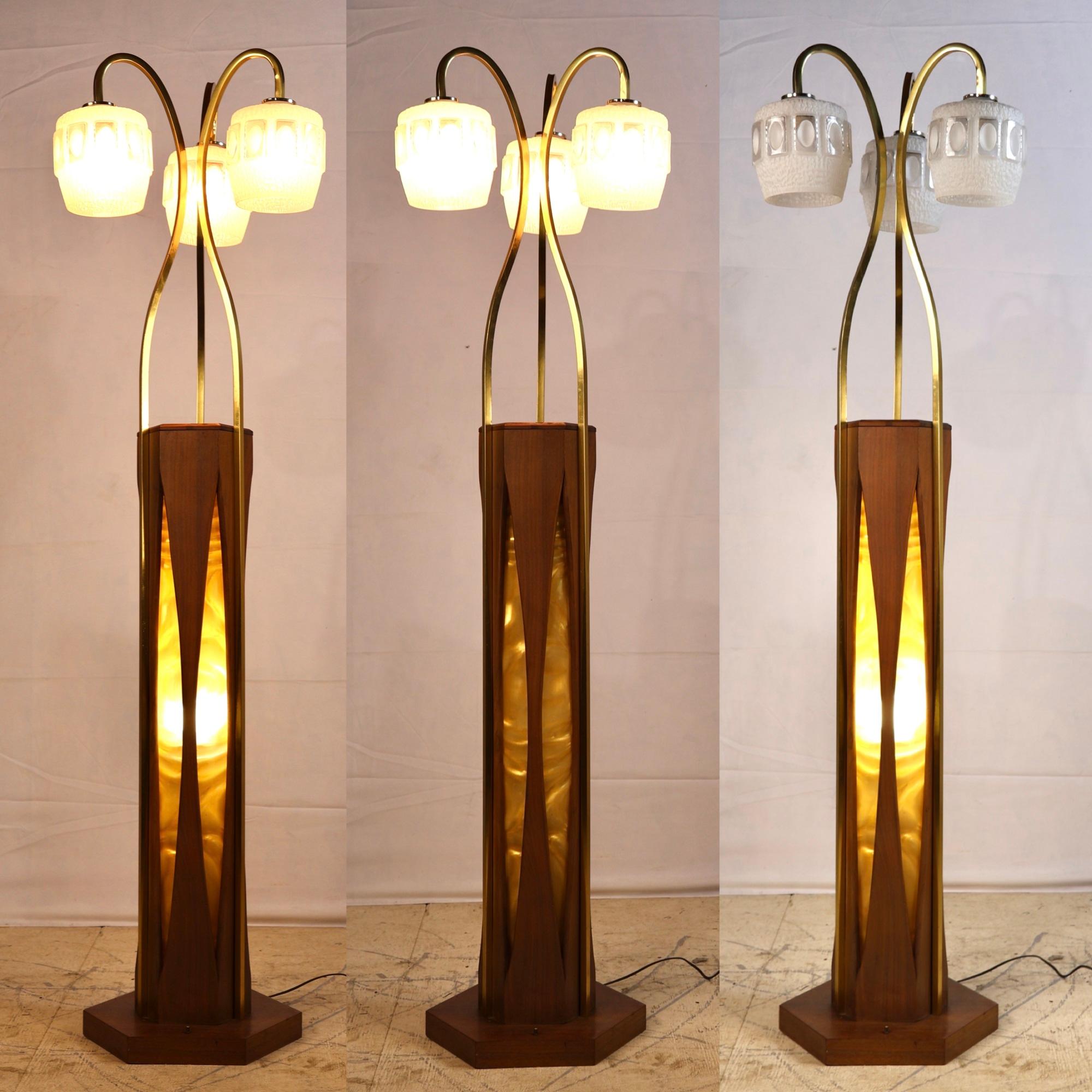 Striking and sculptural, this rare mid-century modern floor lamp by Otto Guggenheim blends warm materials with futuristic form. A hexagonal walnut base anchors the piece, showcasing an internal yellow satin flame diffuser that casts a soft, ambient