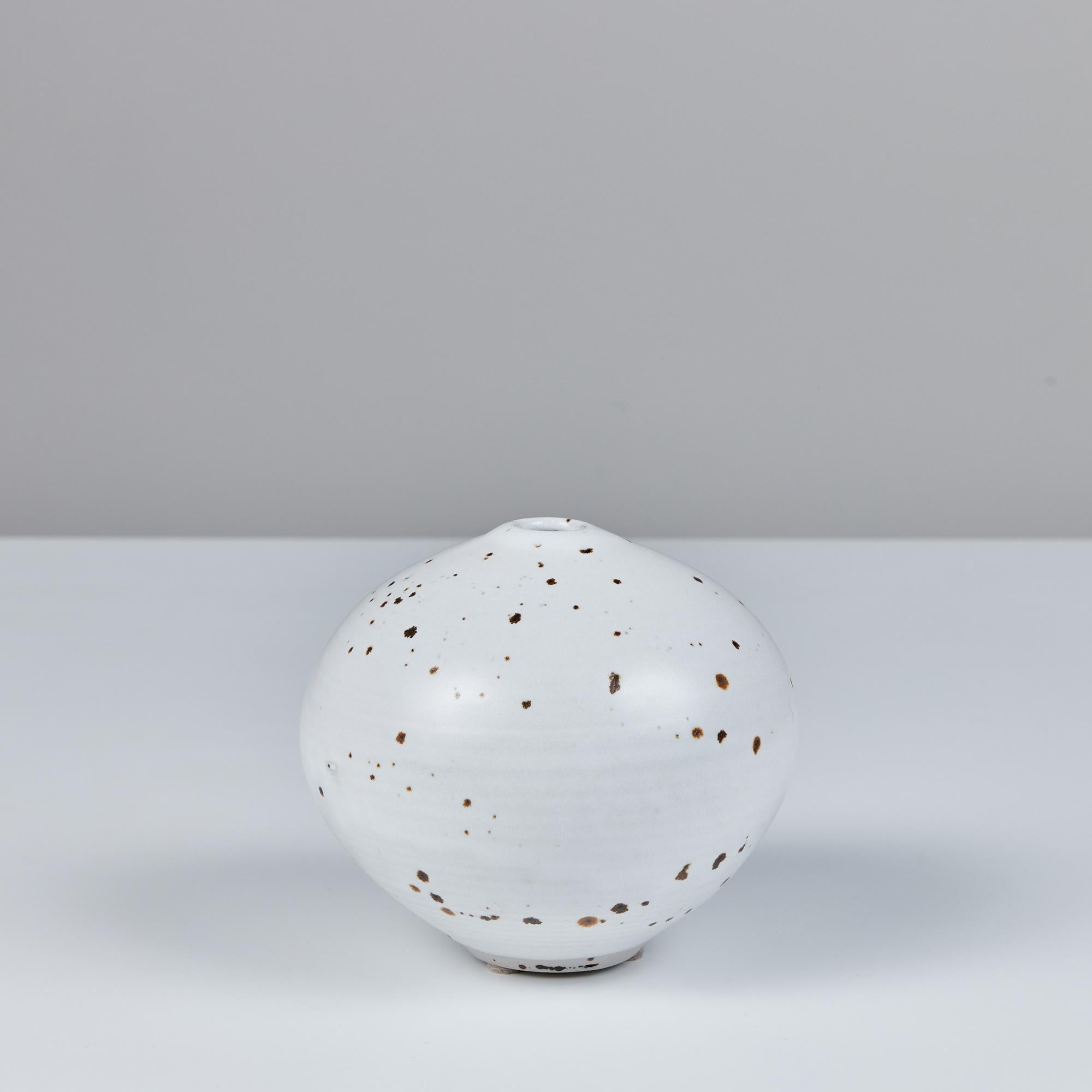 A small studio pottery vessel by significant 20th century ceramicist Otto Heino. This rounded bud vase features a white speckle glaze and ribbed texture.
Signed on the underside, “Otto ‘99.”

Dimensions
5” diameter x 4.75”