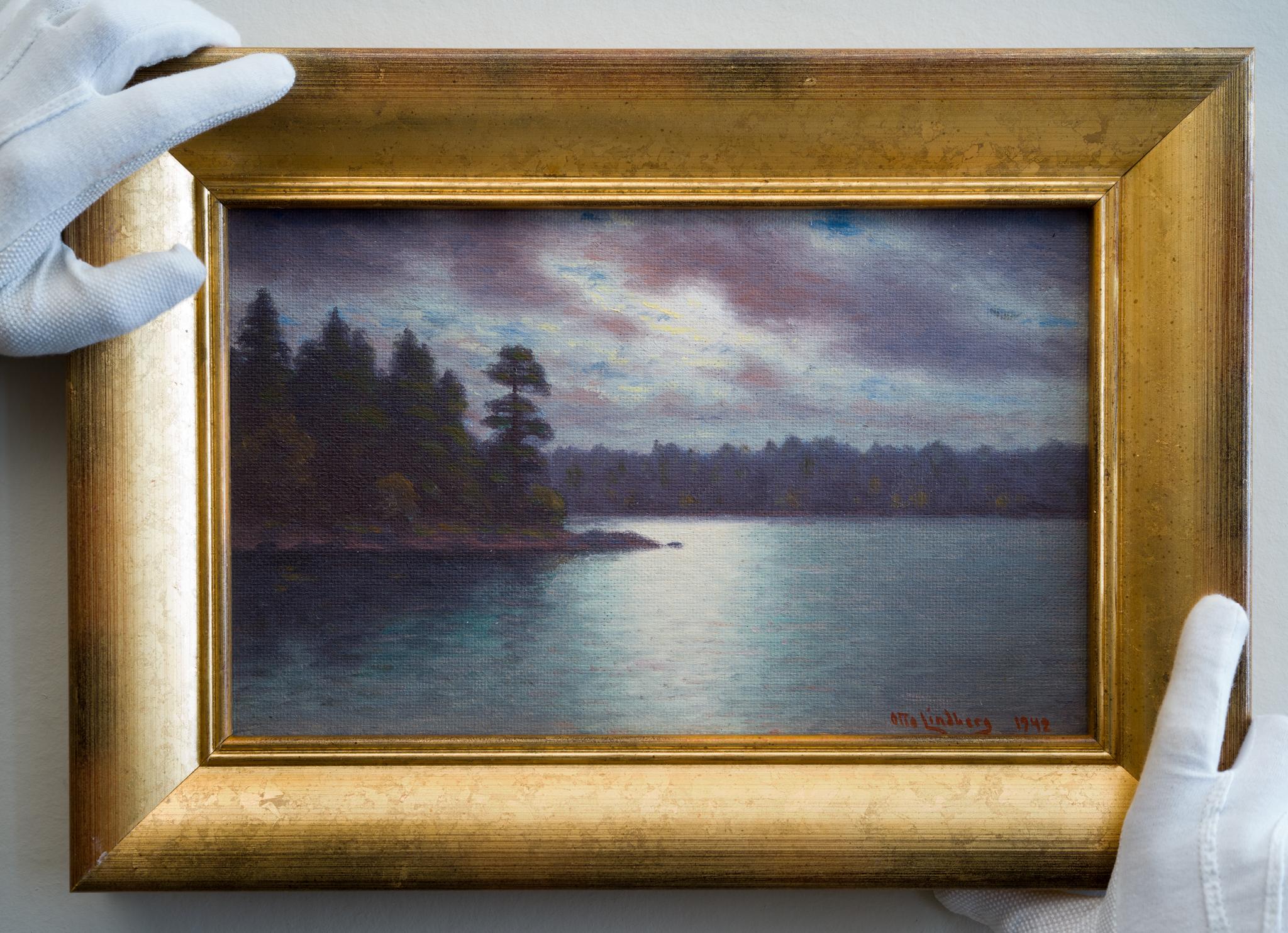 This small yet captivating painting depicts the shimmering moonlight casting its ethereal glow over a tranquil Swedish lake. To the left, an island adorned with trees emerges, while in the background, a landmass covered in foliage completes the
