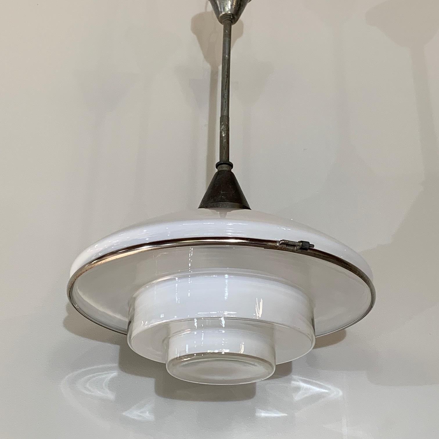 A pendant light by Otto Muller for Sistrah. 

P4 - 40 cm diameter version. 

Germany, circa 1931.

Composed of two main glass elements, a white opaline glass dome and an inverted ziggurat shaped opaline glass shade. Chrome-plated belt.
