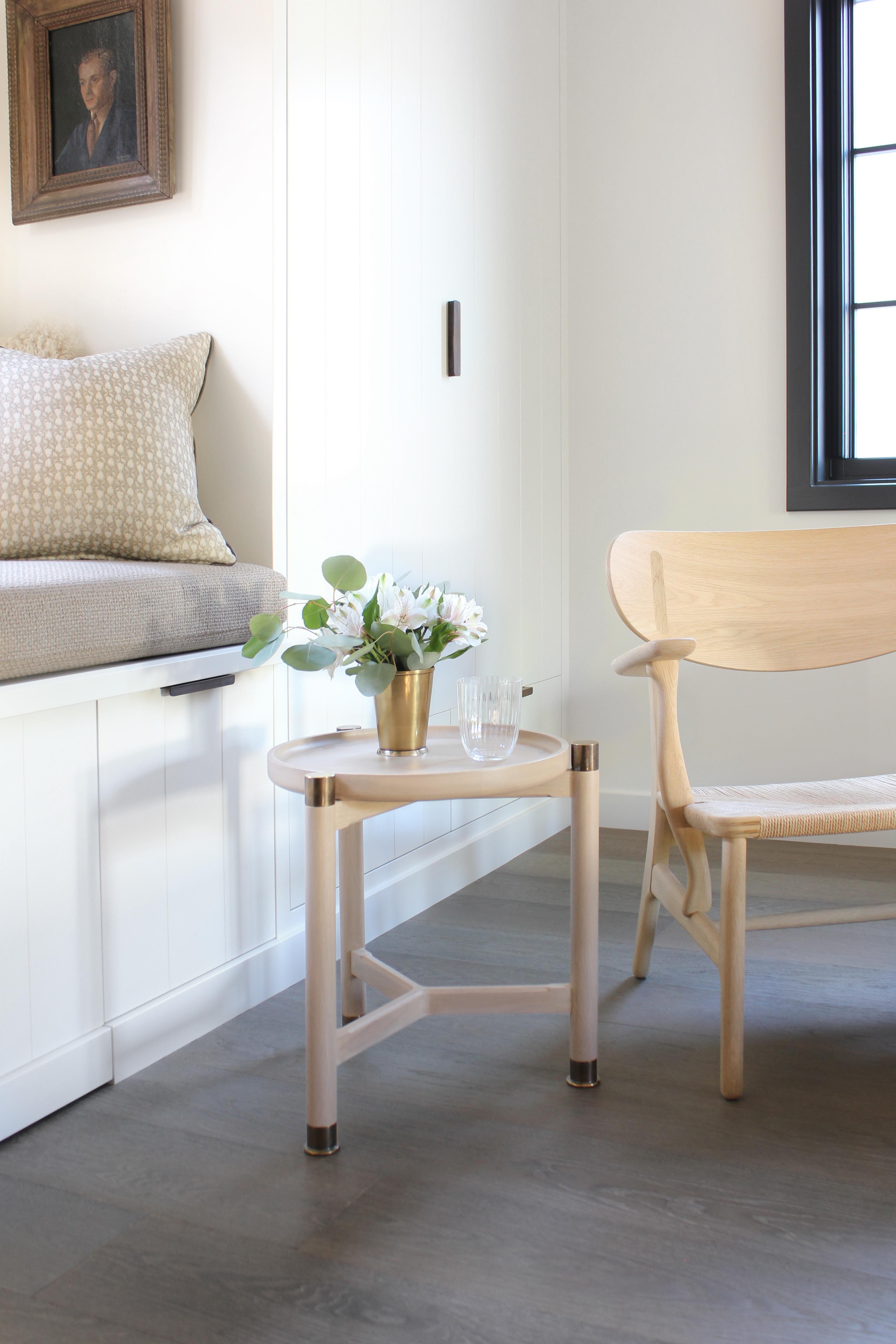 The Otto accent table is a small-scaled table with a Classic, simple, form. 
Available in oak or walnut, it features a round coupe top, substantial antique brass fittings and sleek chamfered stretchers. The epitome of understated elegance - it works