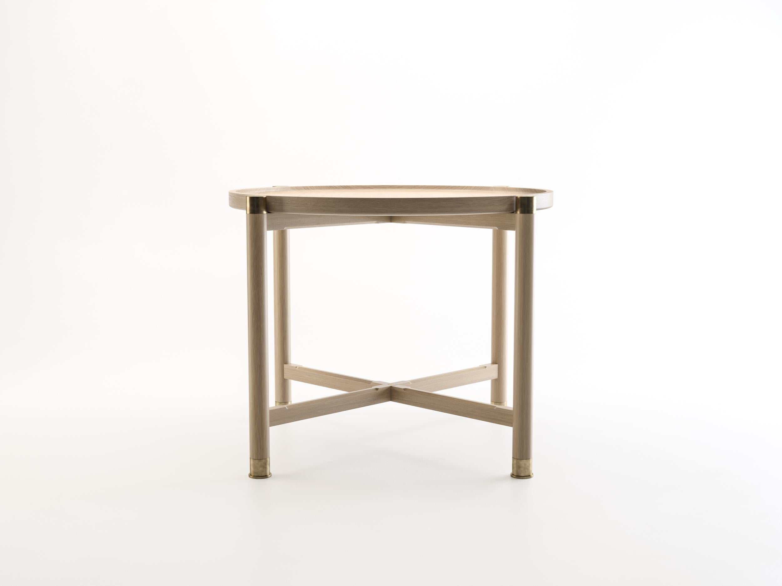 The Otto side table is a generously proportioned table with a simple, well-articulated form.
Available in oak or walnut, it features a round coupe top, substantial antique brass fittings, and sleek chamfered stretchers. The epitome of understated