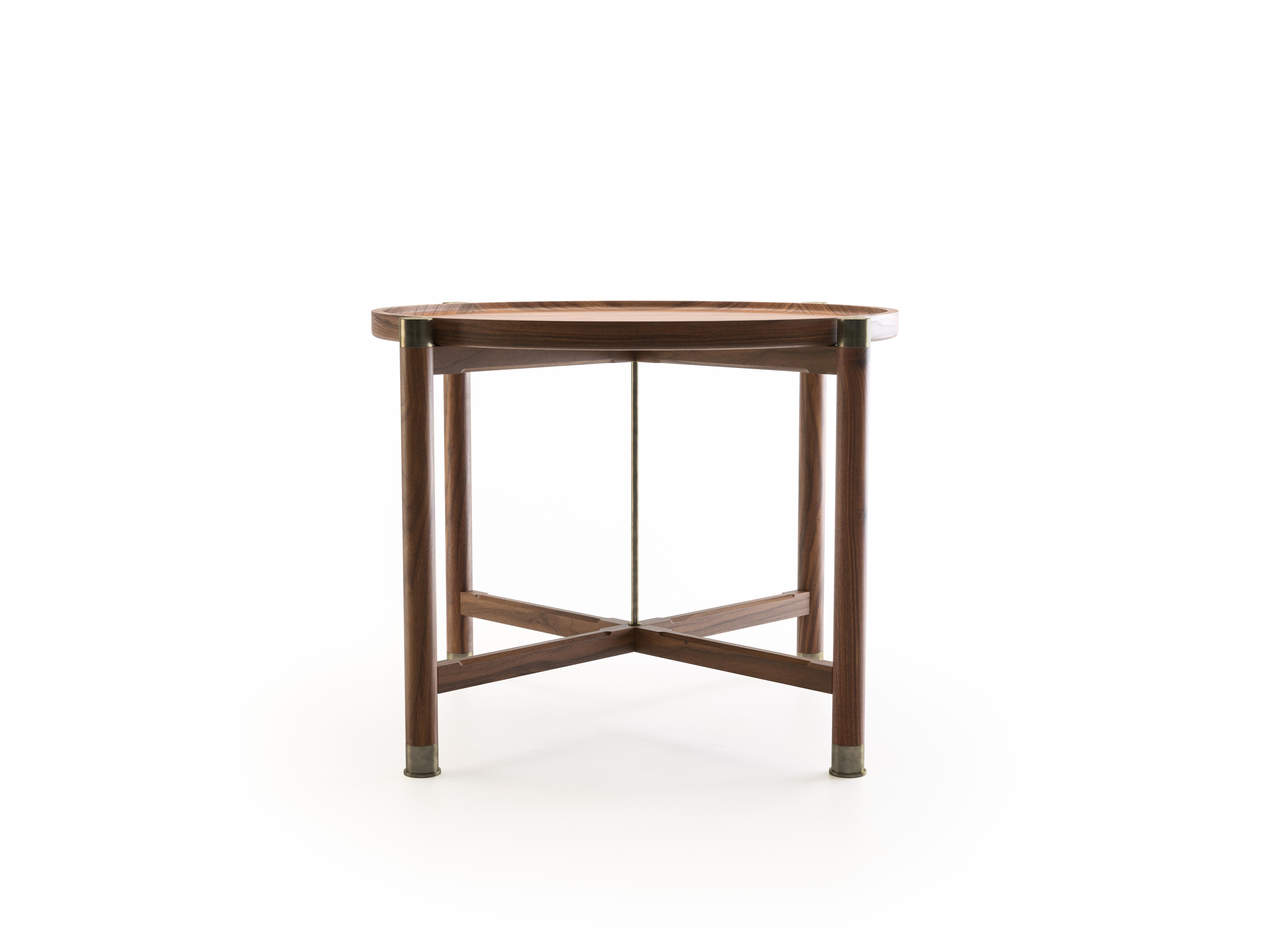 The Otto side table is a generously proportioned table with a simple, well, articulated form.
Available in walnut or oak, it features a round coupe top, substantial antique brass fittings, a central brass stem, and sleek chamfered stretchers. The