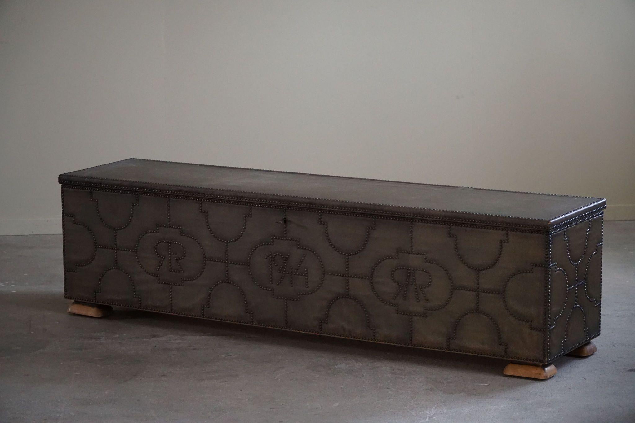 A rare refined chest/bench designed by Otto Schulz for BOET, Gothenburg, in 1944. The piece is covered in antique patinated faux leather, adorned with 
