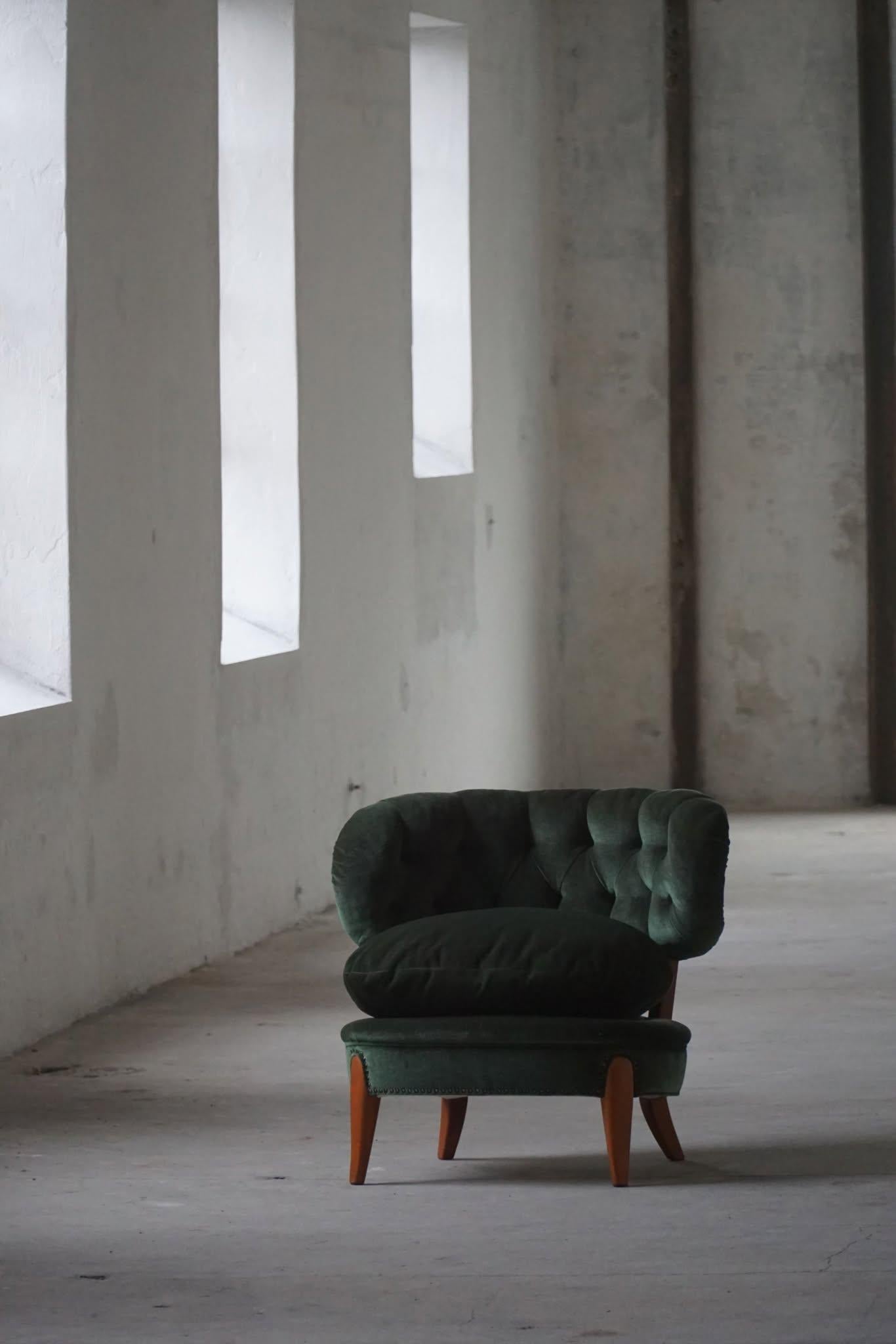 An amazing lounge chair by the famous German born furniture designer Otto Schulz for Boet in Sweden. This chair is from the 50s and remains in a good vintage condition, with the original green velvet fabric. Dry padding in the backrest, but still