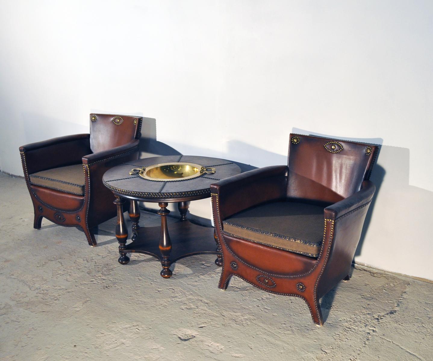 Otto Schulz lounge chairs with original leather and brass nailhead. Round low table with patinated leather top and brass nails and centre brass bowl. Designed in the 1930s and manufactured by Boet in Gothenburg, Sweden.
Patinated with signs of wear