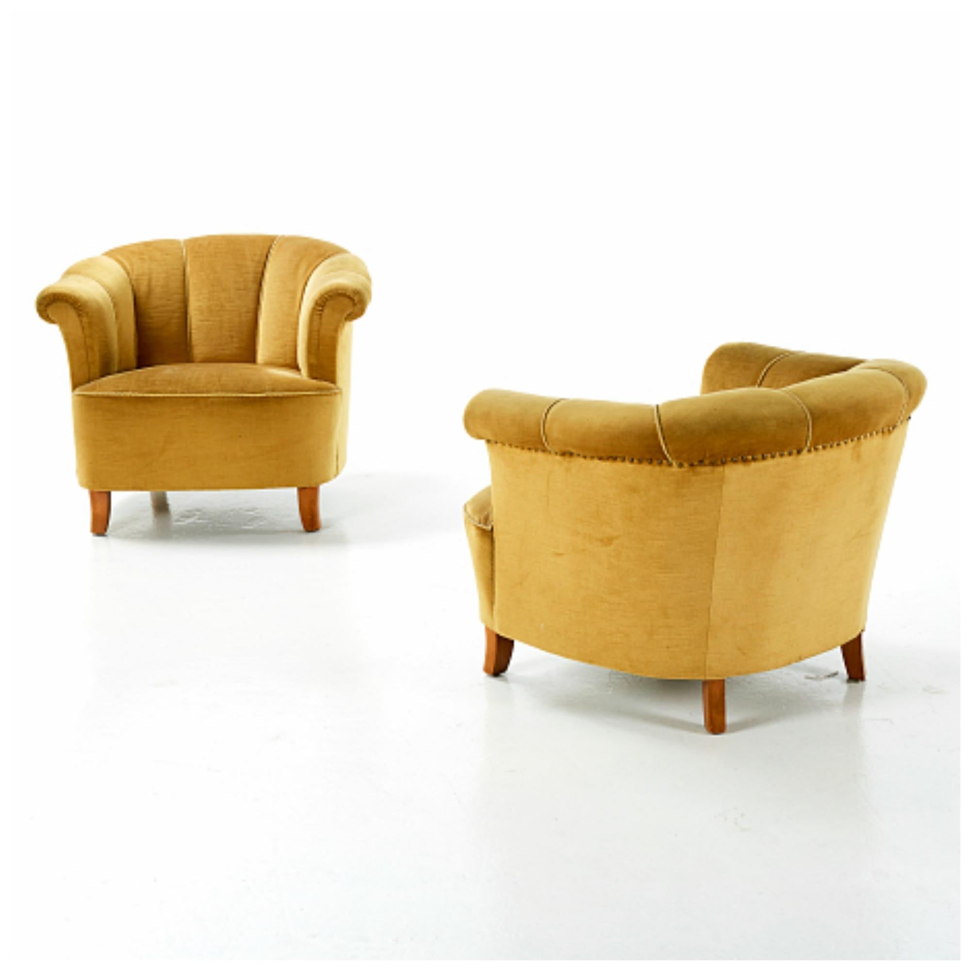 Superb pair of 1940s lounge chairs attributed to Otto Schulz designed for Boet - Schulz' own high-end retail store in Gothenburg, Sweden. The chairs in wool and birch wood with brass tacks is very representative of his innovative low swung designs