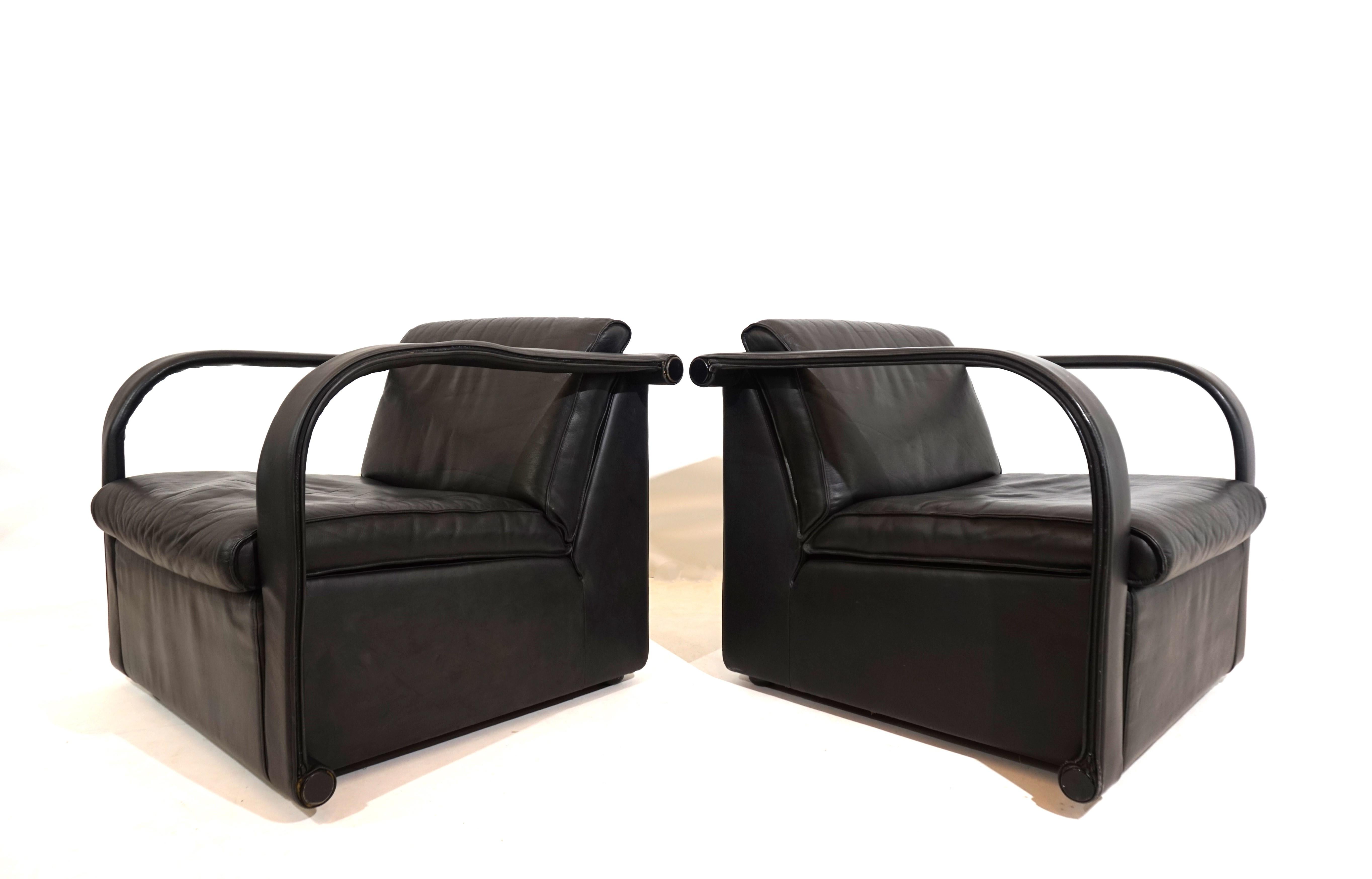 This pair of Arcona leather armchairs by Otto Zapf comes in very good condition. The thick black leather shows only minimal signs of wear. The back and seat cushions, as well as the leather coverings on the armrests, are attached with a zipper