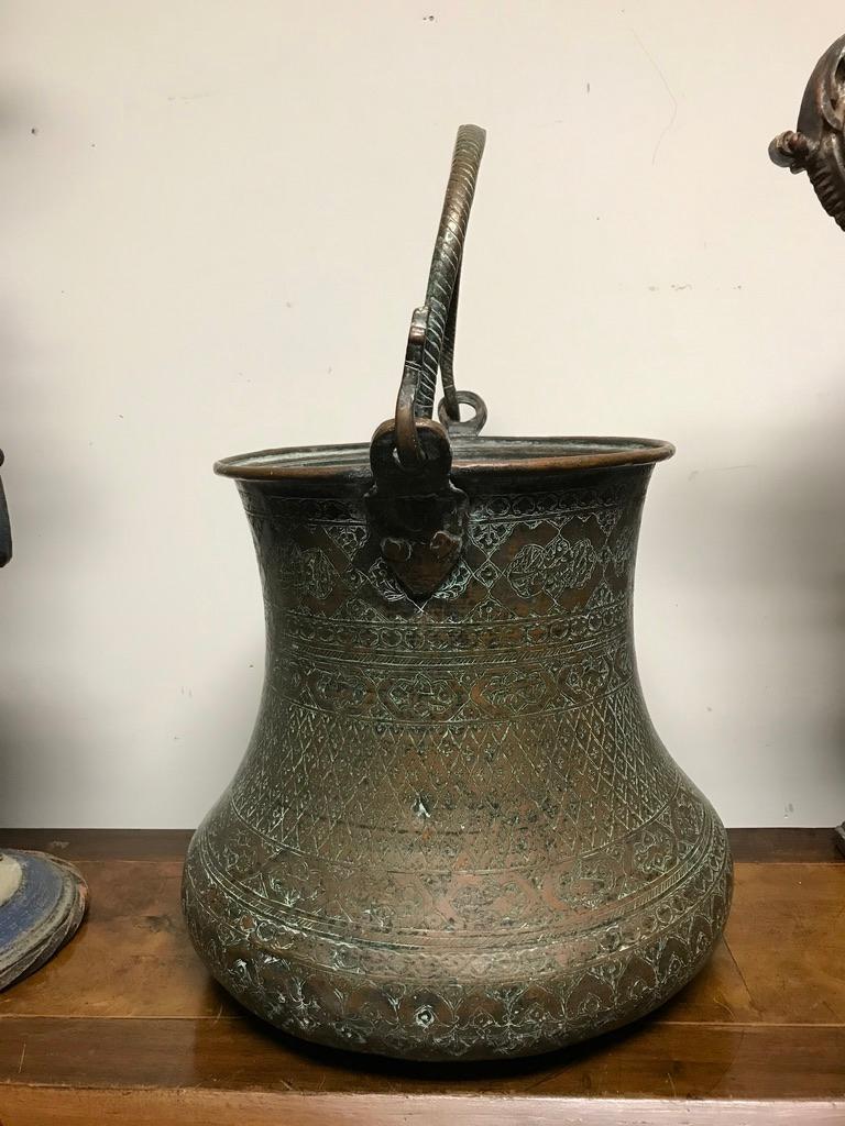 18th century Turkish copper bucket with elaborate etched designs covering the surface. A wonderful shape with the wide bulbous bottom tapering up elegantly. The solid copper loop handle with also decorated, ending in serpent heads. The copper body