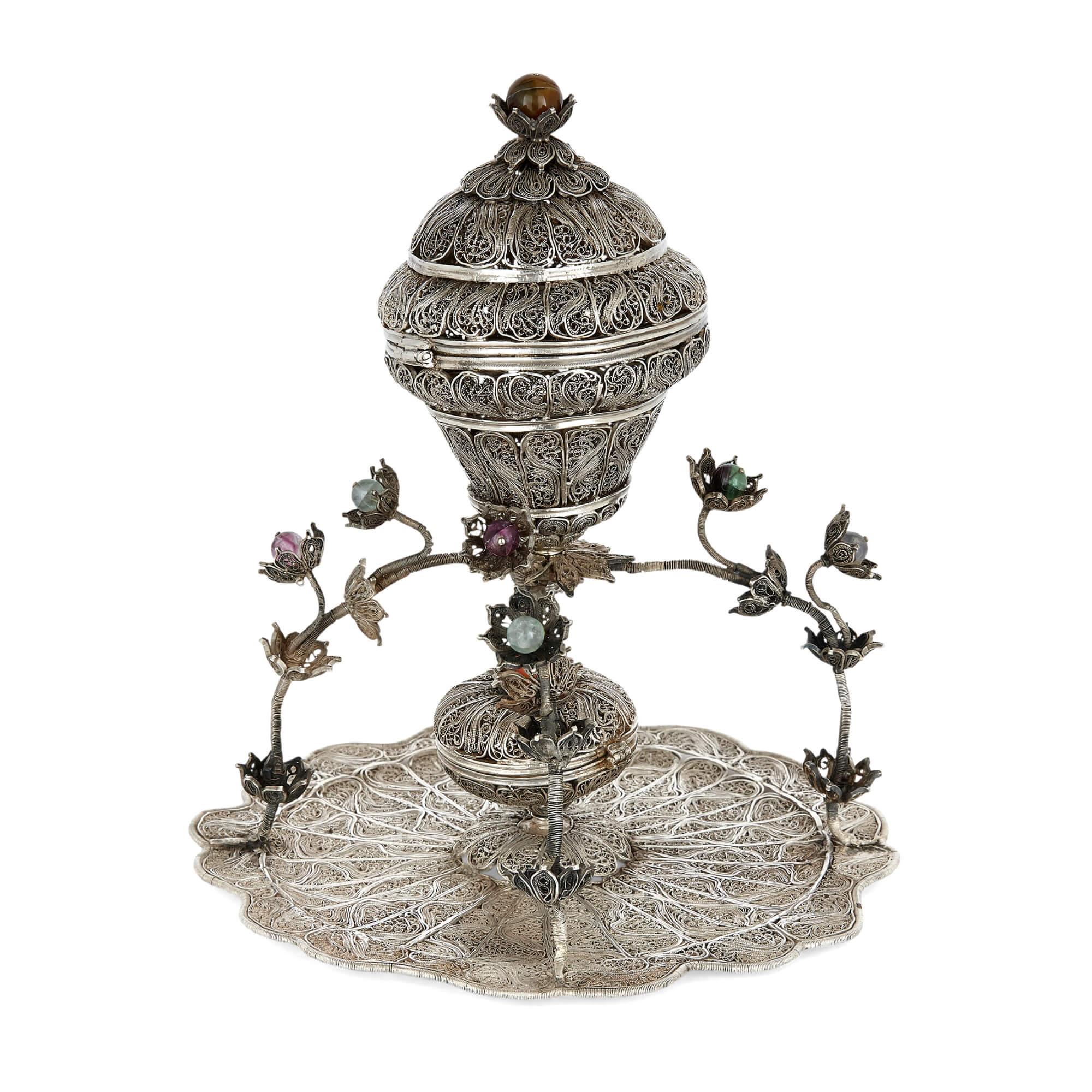 Ottoman filigreed silver and hardstone sweets dish
Turkish, 19th century
Height 24cm, diameter 21cm

This beautiful, filigreed silver item is an Ottoman sweets dish. The piece features a filigree bowl with a hinged and domed lid, supported by