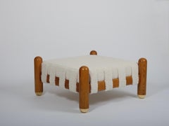 Ottoman in wool boucle, wood and brass