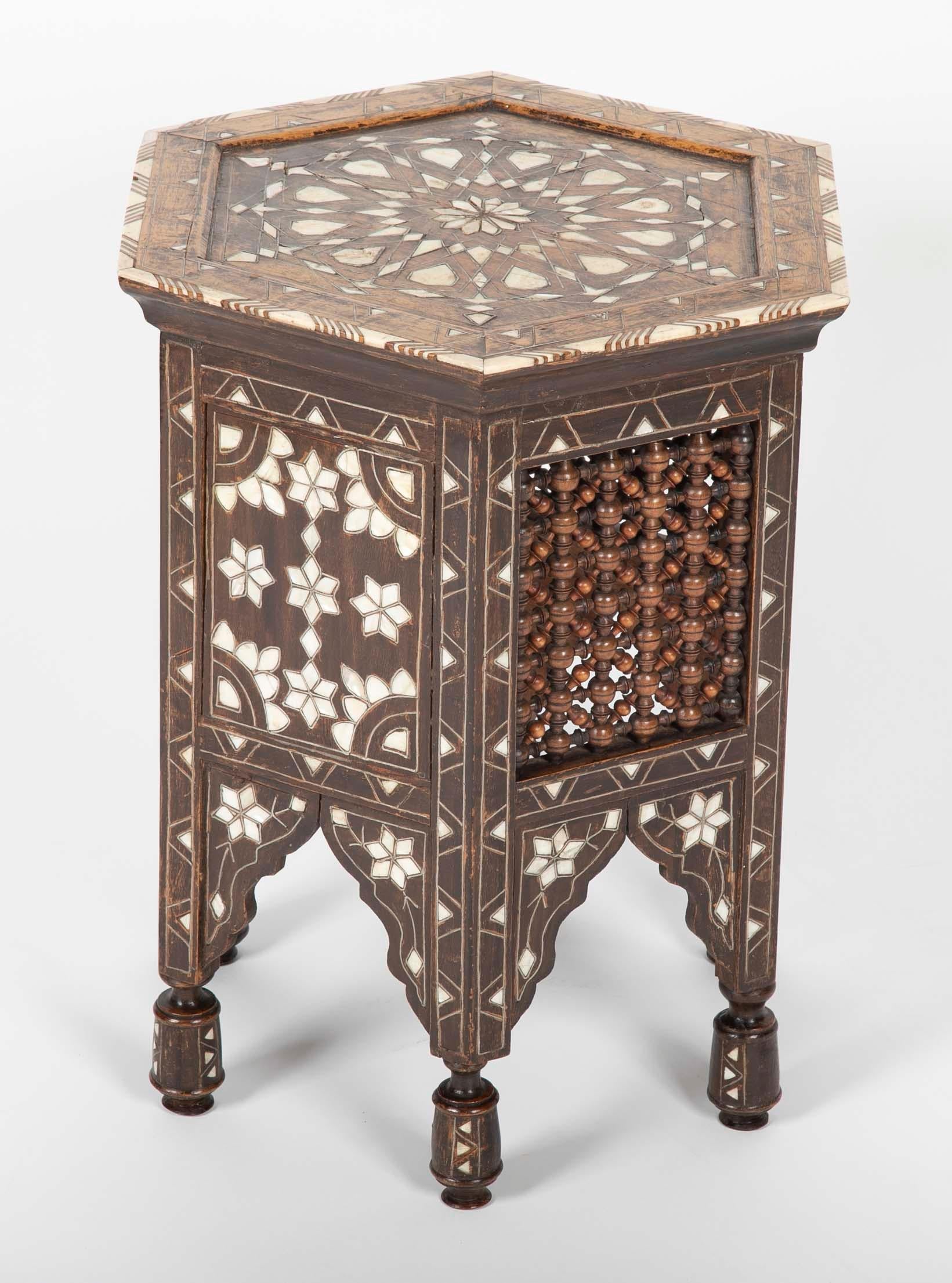 A Turkish hexagonal hardwood side table with bone, metal and mother-of-pearl inlay throughout. This handsome table has alternating side panels of inlay and the delicate wood turnings that make this type of furniture so distinctive.